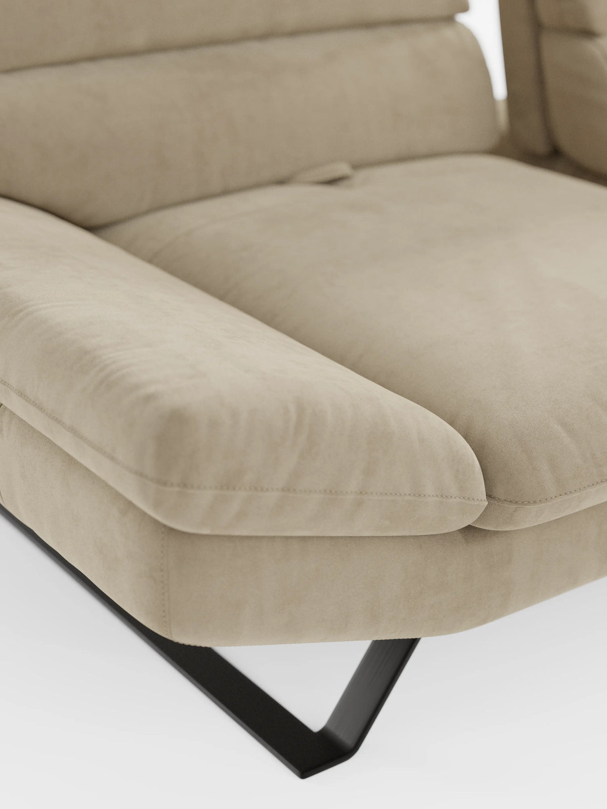 Primo piano del divano angolare Eclipse con penisola e schienali traslanti in microfibra tecnica smacchiabile T11 di Divani.Store, che mette in risalto il suo moderno cuscino in microfibra beige e il bracciolo con rivestimento soffice e lussuoso e cuciture discrete. Il cuscino di seduta, spesso e imbottito, si estende senza soluzione di continuità in una chaise longue per un maggiore relax. La base è caratterizzata da una gamba in metallo nero dal design geometrico angolare, il tutto su uno sfondo bianco.