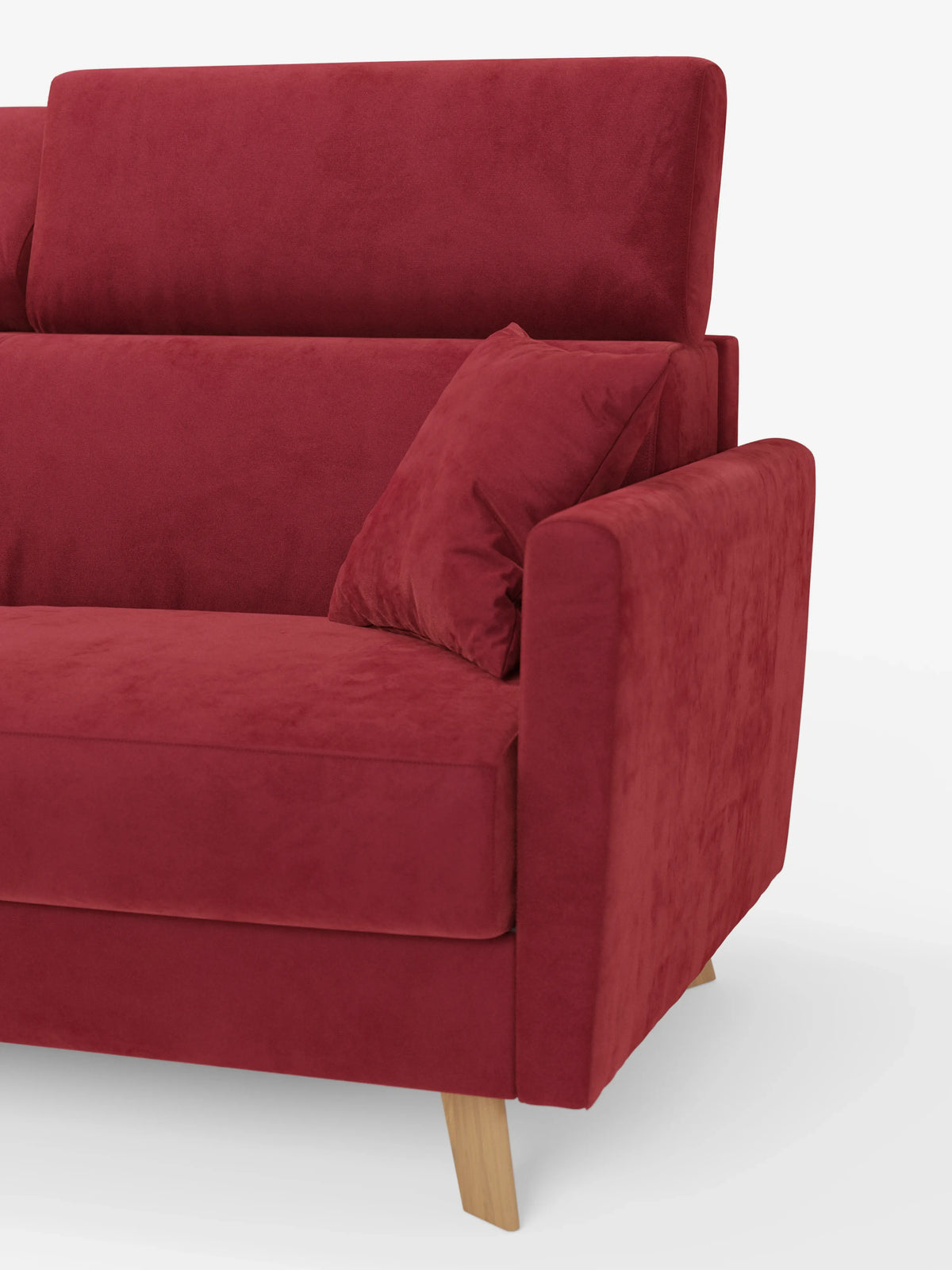 Un primo piano del divano letto Francy con poggiatesta regolabili di Divani.Store, un moderno divano a tre posti in velluto rosso dotato di un unico cuscino di seduta, un cuscino decorativo e gambe in legno. Il bracciolo è ampio e imbottito, mentre lo sfondo è bianco a tinta unita. Questo modello è sfoderabile al 100% e rivestito con l'elegante tessuto T30 resistente alle macchie.