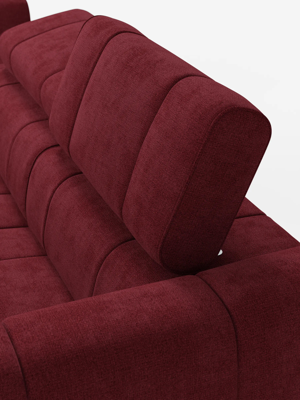 Primo piano dall'alto di un divano componibile Giotto di colore rosso intenso con terminale aperto - opzione relax elettrico in tessuto smacchiabile T23, caratterizzato da imbottitura verticale a segmenti con trapuntatura e un poggiatesta inclinato su uno sfondo bianco a tinta unita.