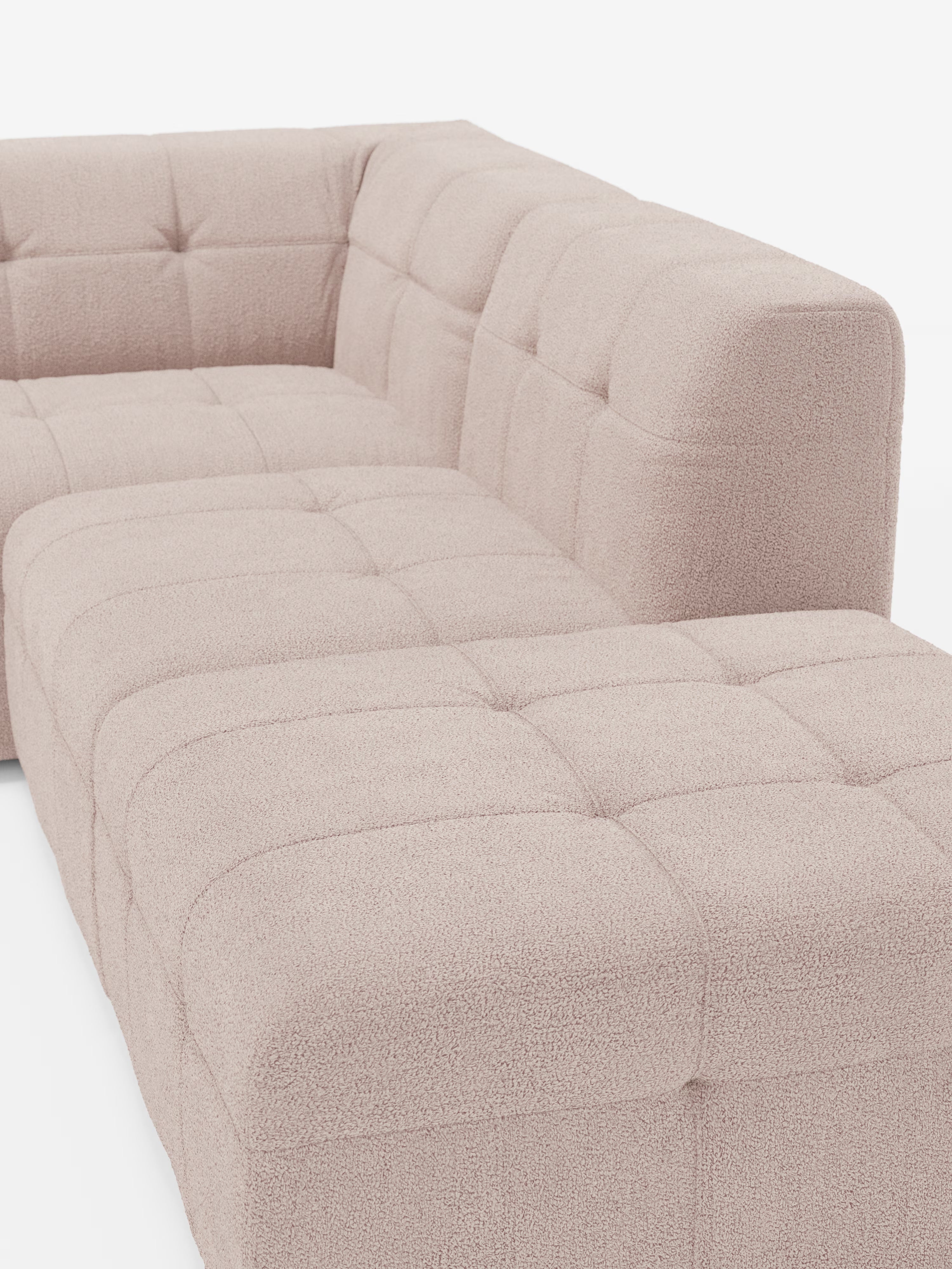 Un divano angolare componibile e modulare Mosaic in bouclé, dal colore beige chiaro e dallo stile contemporaneo: capitonné e design in tessuto smacchiabile T21 di Divani.Store, caratterizzato da un tessuto bouclé trapuntato e dalla trama in rilievo. Questo divano componibile modulare è caratterizzato da uno schienale basso e da un bracciolo destro, con linee pulite e una silhouette squadrata. L’immagine mostra il divano visto di profilo frontale su uno sfondo bianco.