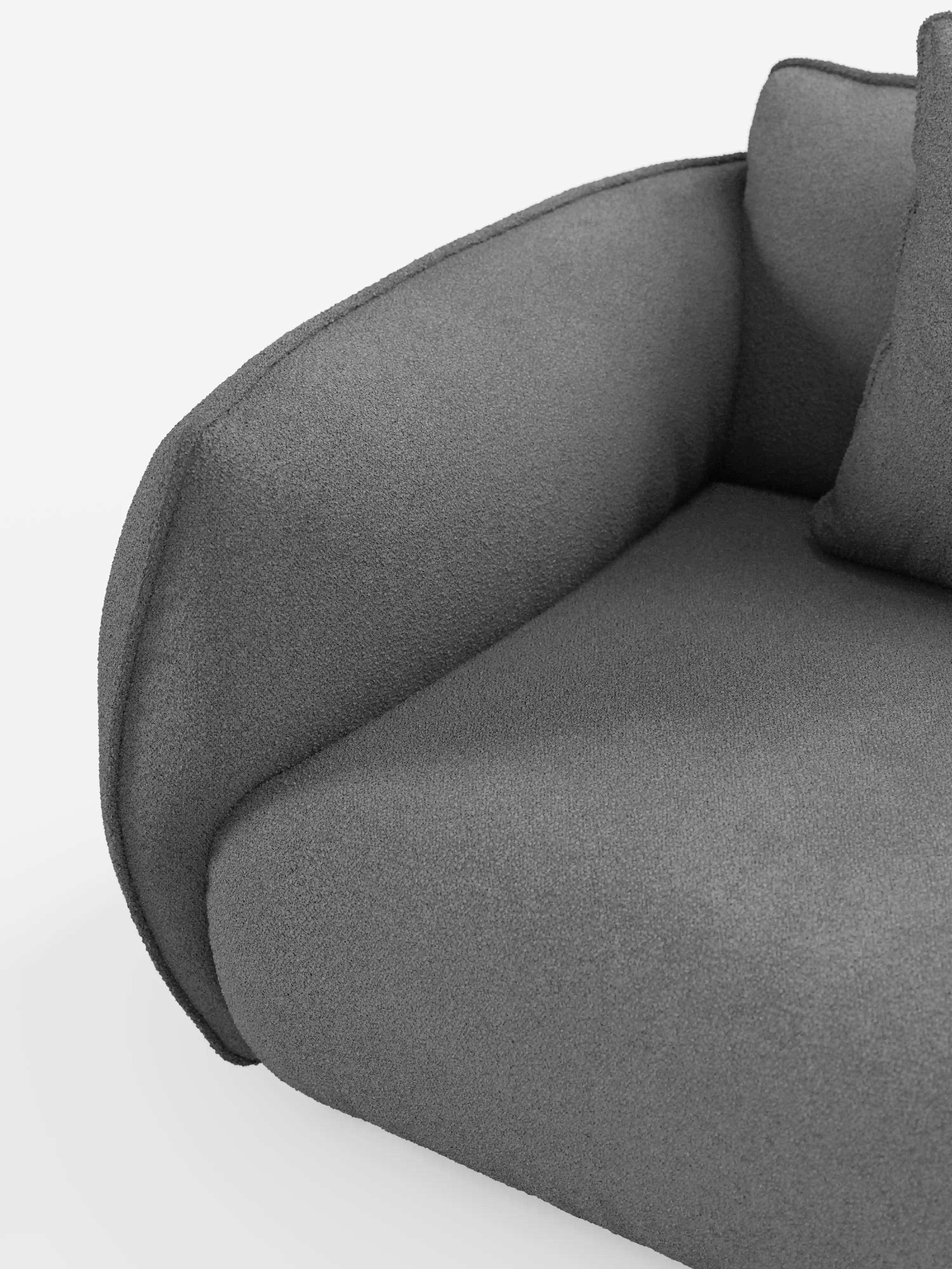 Primo piano del divano modulare a 3 posti “Nimbus” di Divani.Store, qui raffigurato con rivestimento T33 in tessuto grigio scuro, testurizzato, smacchiabile ed effetto cotone. L'immagine mette in risalto il bracciolo arrotondato e il morbido cuscino sul lato sinistro di questo moderno divano modulare, su uno sfondo bianco a tinta unita.