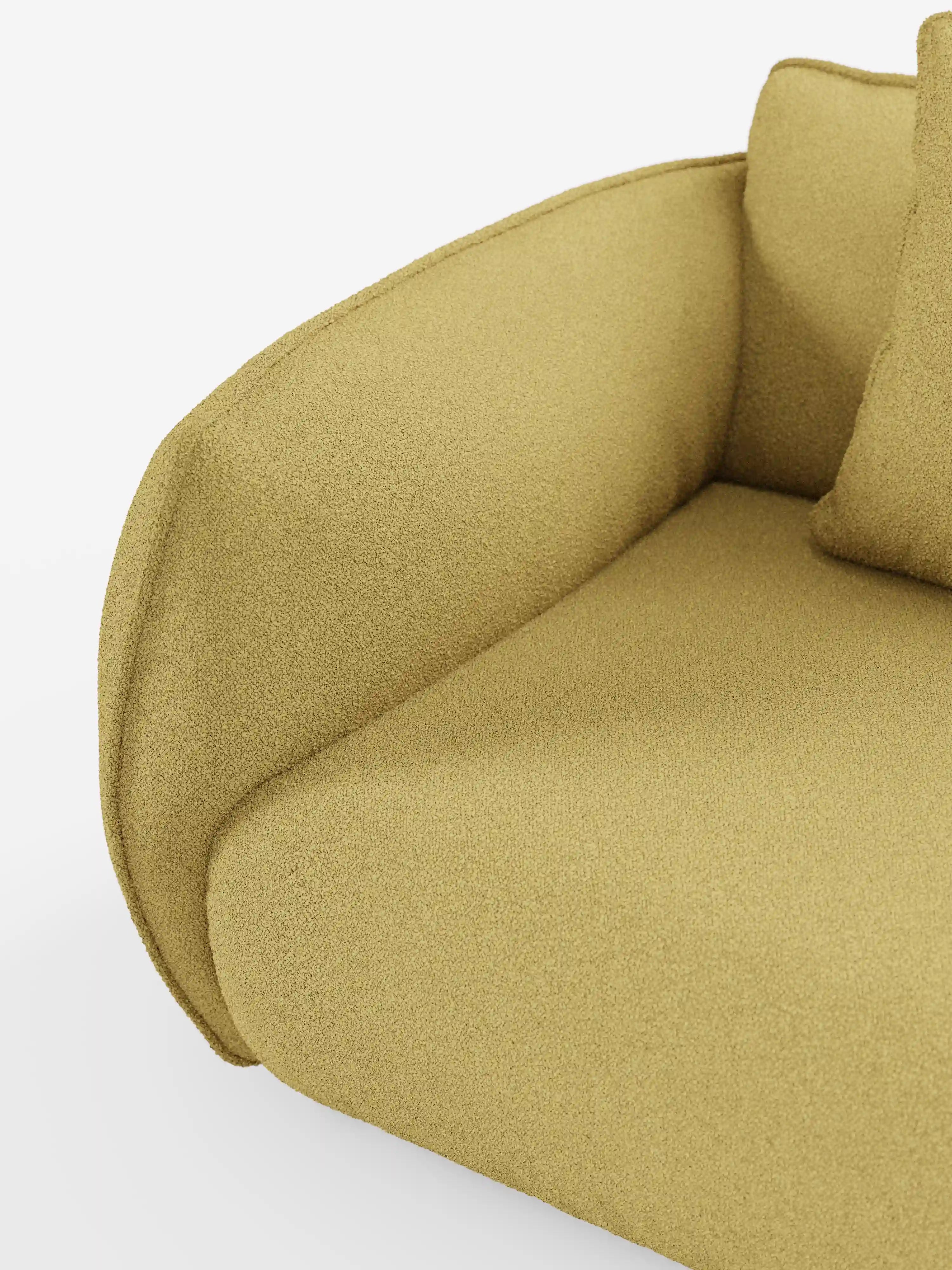 Primo piano del divano modulare a 3 posti Nimbus di Divani.Store, rivestito in tessuto T33 effetto cotone di colore giallo senape, facile da pulire. L'immagine mette in risalto il bracciolo ricurvo, il morbido cuscino e una parte di un cuscino quadrato, conferendo al divano un aspetto morbido e accogliente su uno sfondo bianco a tinta unita.