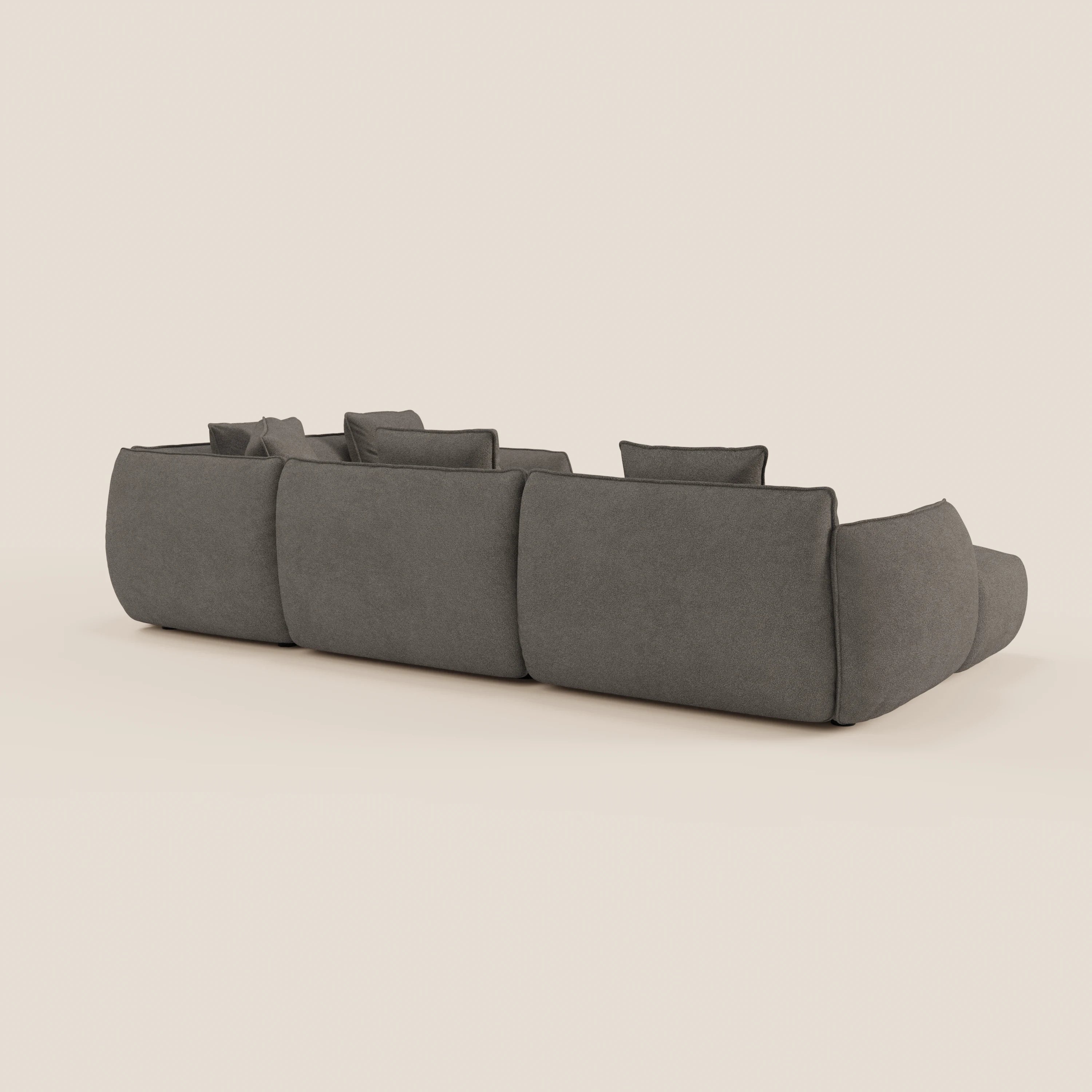 Il divano Nimbus angolare panoramico componibile con penisola e angolo in tessuto smacchiabile t33 di Divani.Store è presentato dal retro, con tessuto grigio scuro, tre grandi cuscini di schienale e bordi morbidi e arrotondati.