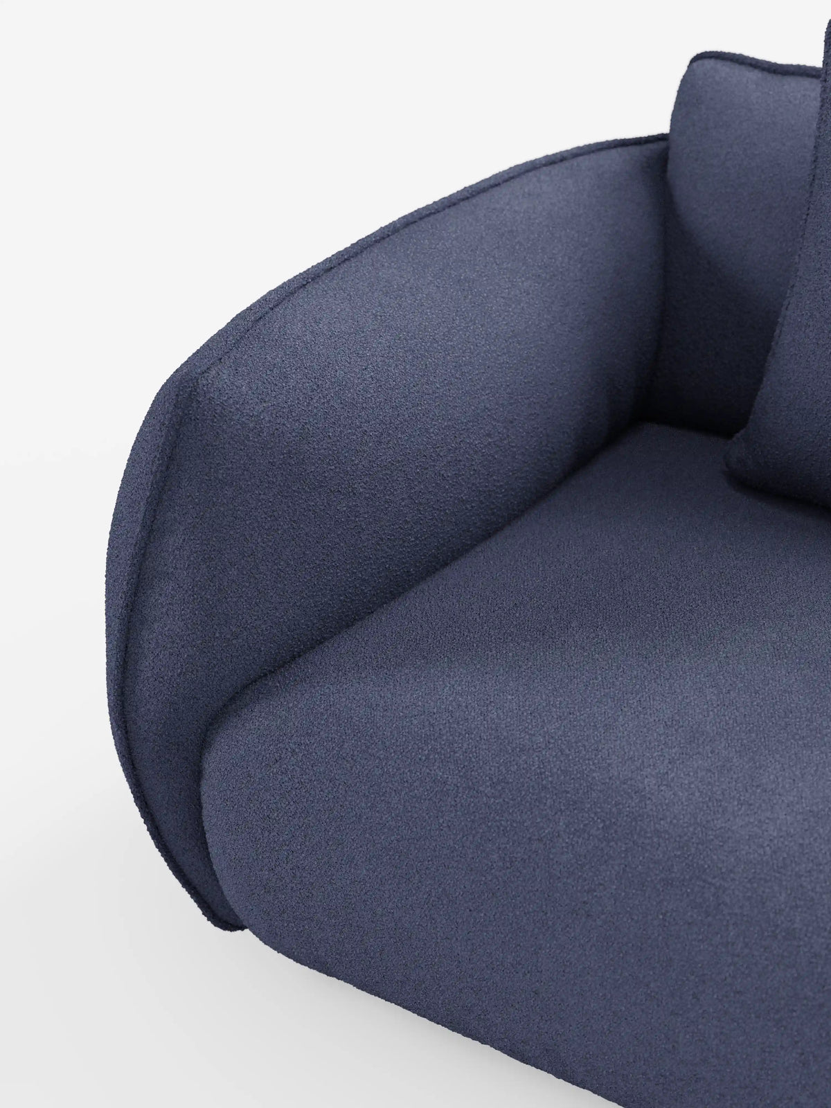 Primo piano del divano Nimbus a 3 posti, modulare e componibile, da 250 cm di Divani.Store, caratterizzato da un'imbottitura morbida e da bordi arrotondati, rivestito in tessuto effetto cotone blu scuro, sfoderabile e antimacchia (t33). Il bracciolo e la seduta, di notevole spessore, sono completati da un cuscino coordinato, parzialmente visibile su uno sfondo bianco a tinta unita.