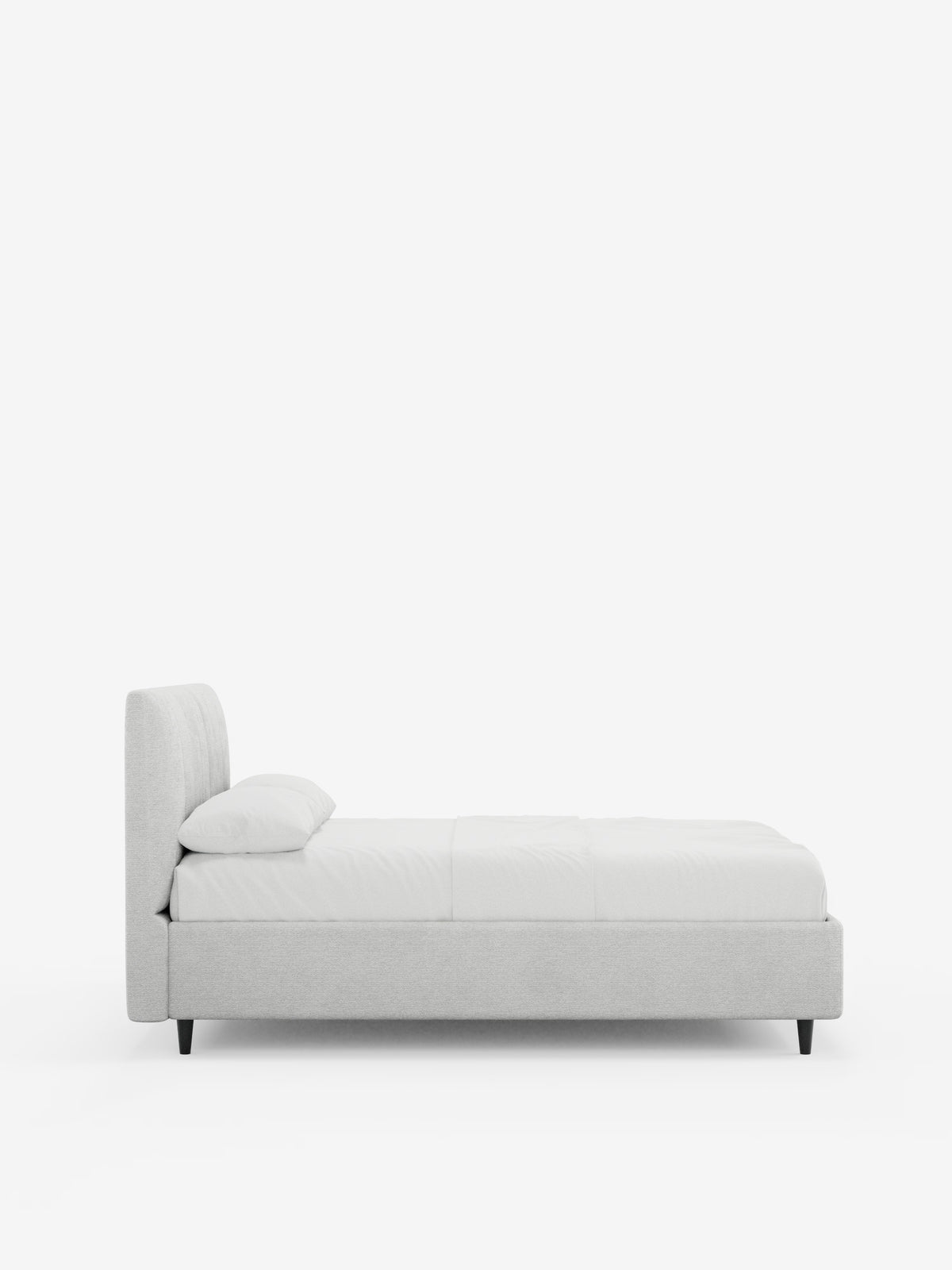 Una vista laterale minimalista del letto imbottito ONYX con contenitore e testiera verticale in tessuto certificato Oeko-Tex® di Letti.store, che mette in risalto una testiera imbottita grigio chiaro con cuciture verticali, un profilo basso, un unico cuscino bianco e una biancheria da letto candida su uno sfondo bianco a tinta unita. Il letto è sostenuto da quattro gambe corte e scure.