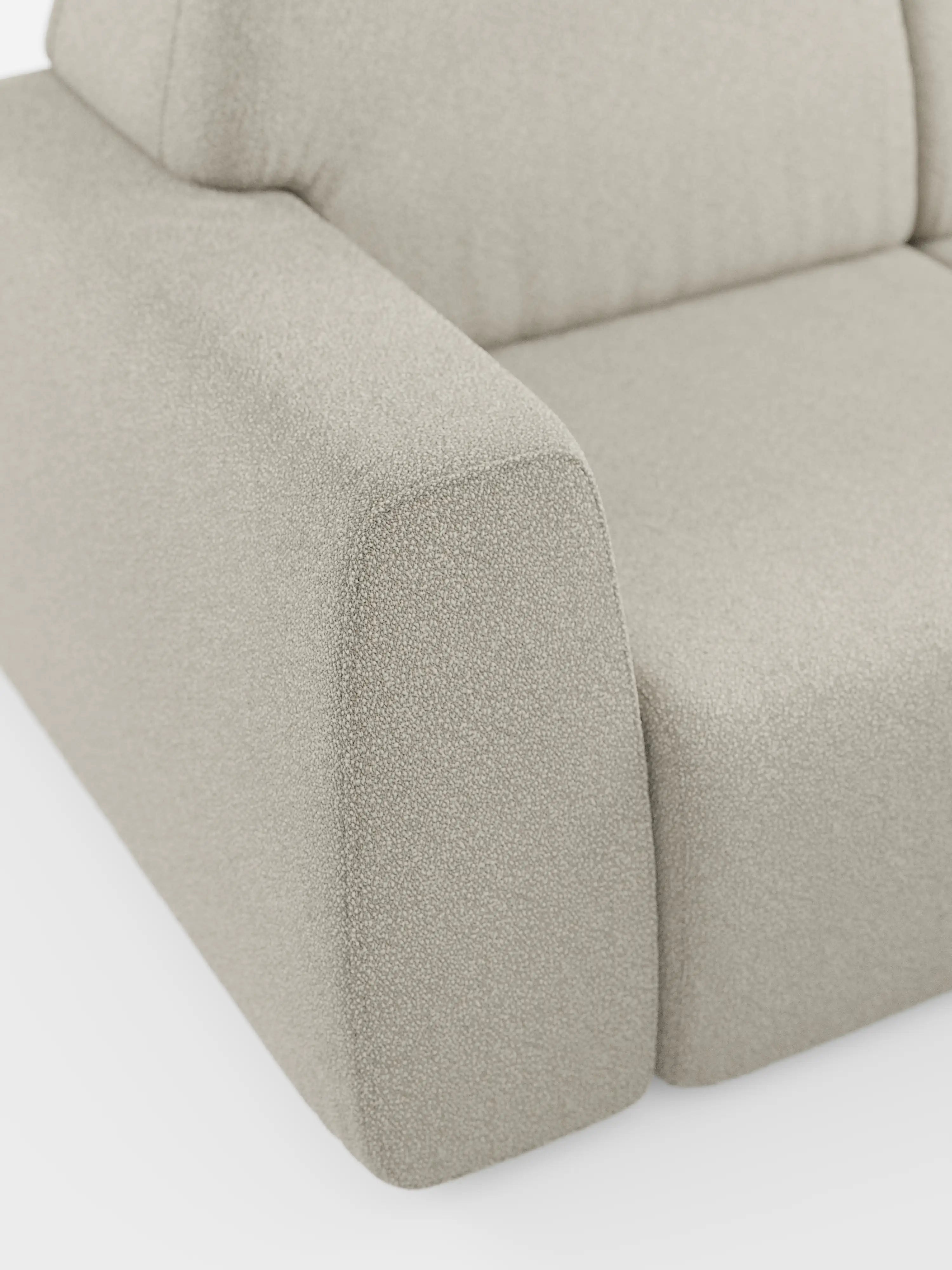 Primo piano del divano Orbit con 3 sedute scorrevoli e allungabili in tessuto effetto cotone smacchiabile T33 di Divani.Store, caratterizzato da un rivestimento moderno color beige chiaro con bordi morbidi e arrotondati e tessuto testurizzato. L'immagine mette in risalto il bracciolo, la seduta e una parte dello schienale, evidenziando le tre sedute scorrevoli e allungabili che garantiscono un comfort versatile, il tutto su uno sfondo bianco minimalista che ne esalta il design contemporaneo.