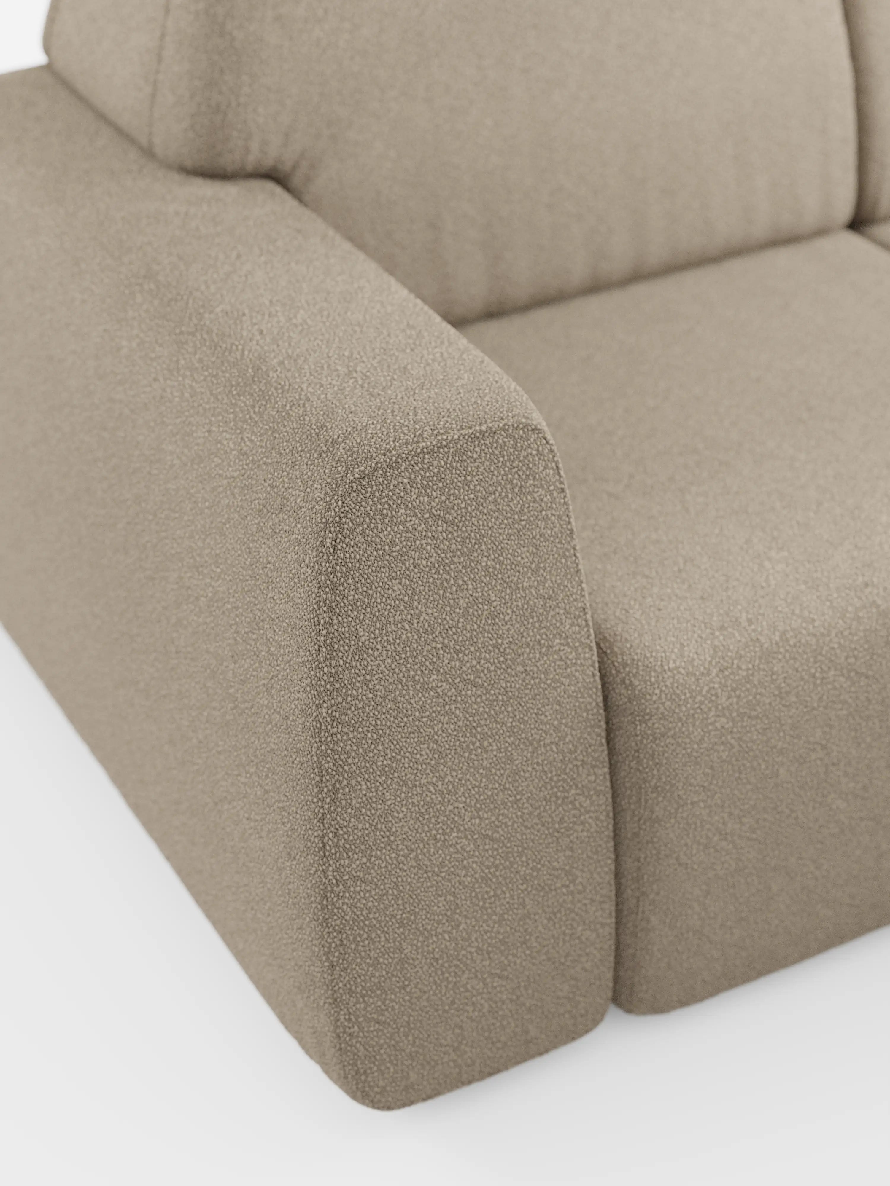 Primo piano del bracciolo e del cuscino di seduta del divano Orbit con 3 sedute scorrevoli e allungabili di Divani.Store, rivestito in tessuto T33 effetto cotone resistente alle macchie, color beige chiaro. Il design squadrato dai bordi morbidi risalta sullo sfondo bianco a tinta unita, mettendo in risalto lo stile minimalista e contemporaneo del divano. Questo modello è dotato di rivestimenti completamente sfoderabili per una facile manutenzione.