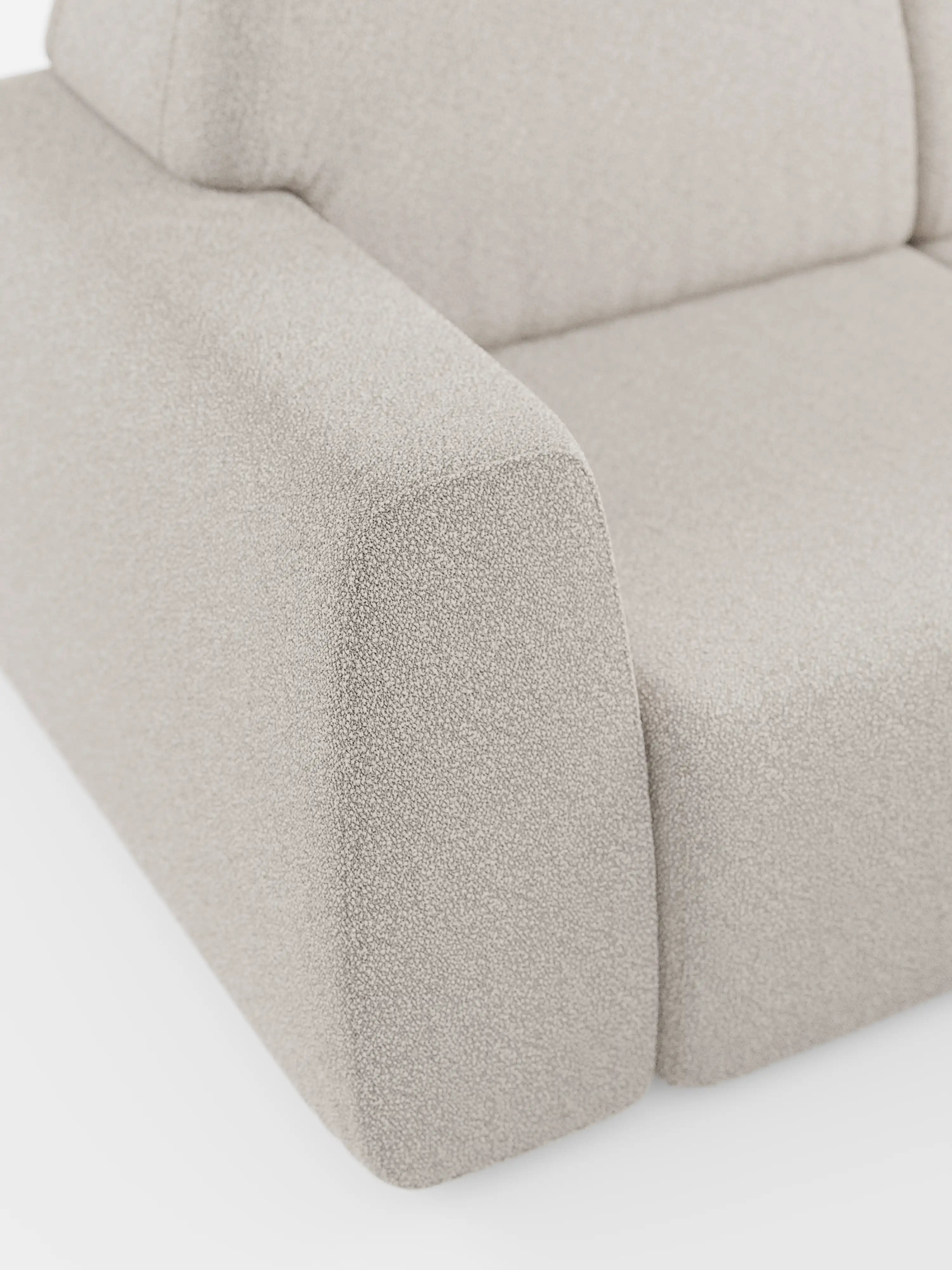 Un primo piano del divano Orbit con 3 sedute scorrevoli e allungabili di Divani.Store mette in risalto un divano moderno, color beige chiaro, rivestito in tessuto T33 antimacchia con una trama effetto cotone. L’immagine mette in risalto il bracciolo sinistro e parte del cuscino di seduta, rivelando linee pulite e minimaliste. Dotato di sedute scorrevoli indipendenti per un comfort personalizzato, questo elegante e versatile divano a 4 posti presenta uno sfondo bianco a tinta unita.
