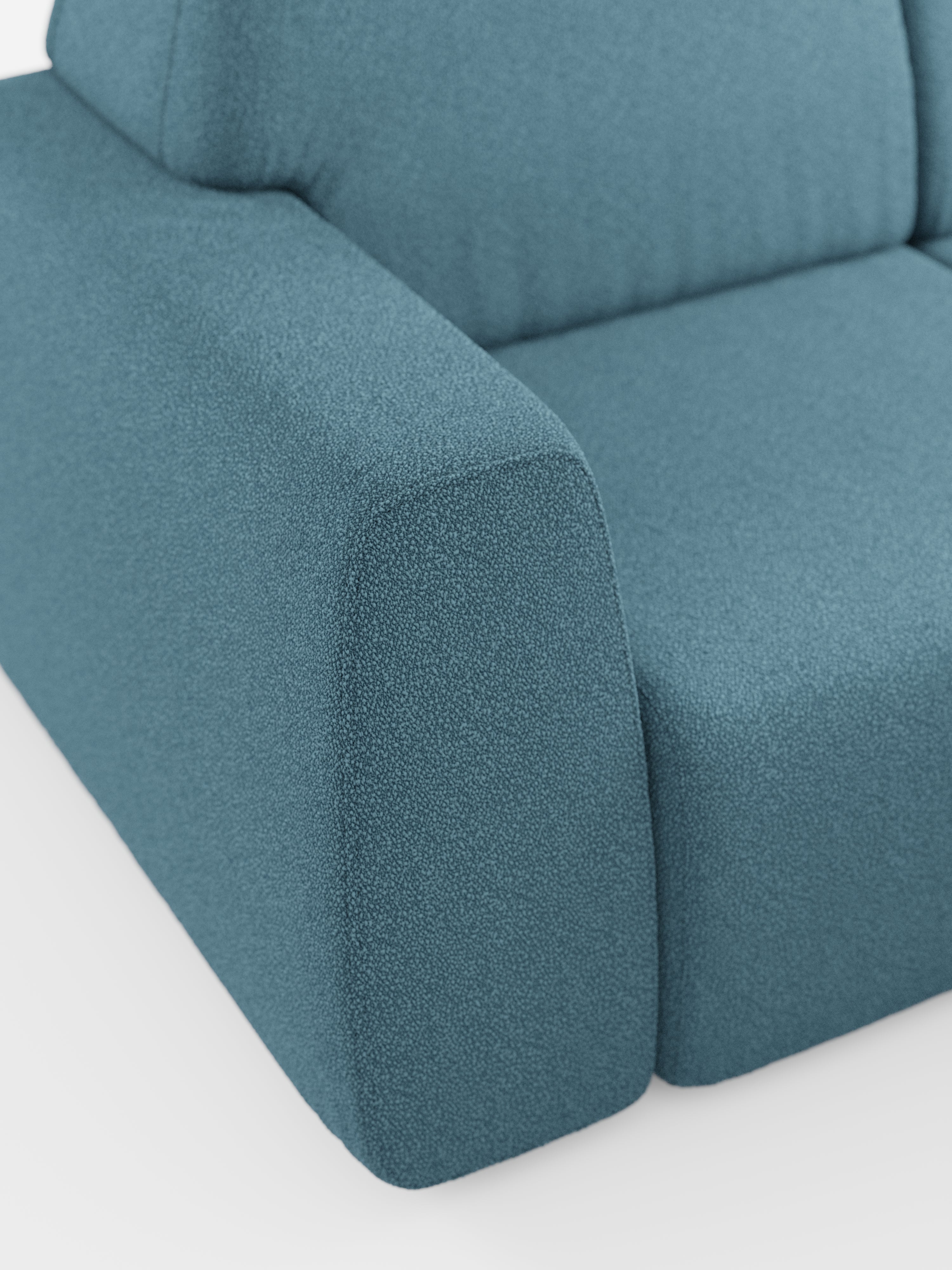 Primo piano del divano angolare Orbit con penisola reversibile e tutte le sedute allungabili di Divani.Store, rivestito in tessuto T33 color verde acqua, effetto cotone e resistente alle macchie. L’immagine mette in risalto il bracciolo e parte del cuscino di seduta, evidenziandone le linee pulite e il rivestimento morbido e materico. Sullo sfondo bianco, la foto esalta il colore e il materiale distintivi di questo moderno divano componibile.