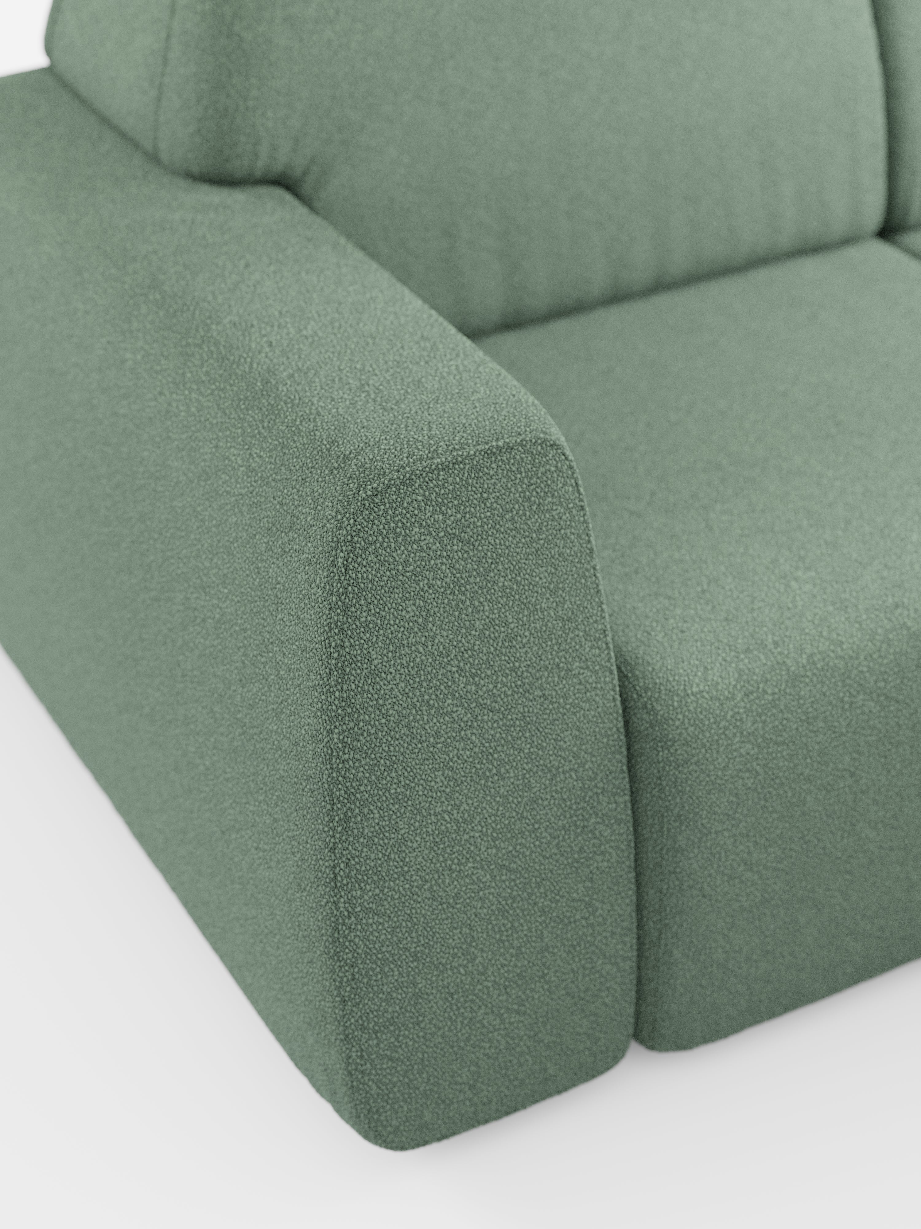 Primo piano del divano angolare Orbit con penisola reversibile e tutte le sedute allungabili di Divani.Store, che mette in risalto i braccioli arrotondati e il cuscino di seduta rivestito in tessuto T33 effetto cotone resistente alle macchie. Il design morbido e lussuoso presenta curve sinuose e una delicata tonalità di verde salvia su sfondo bianco.