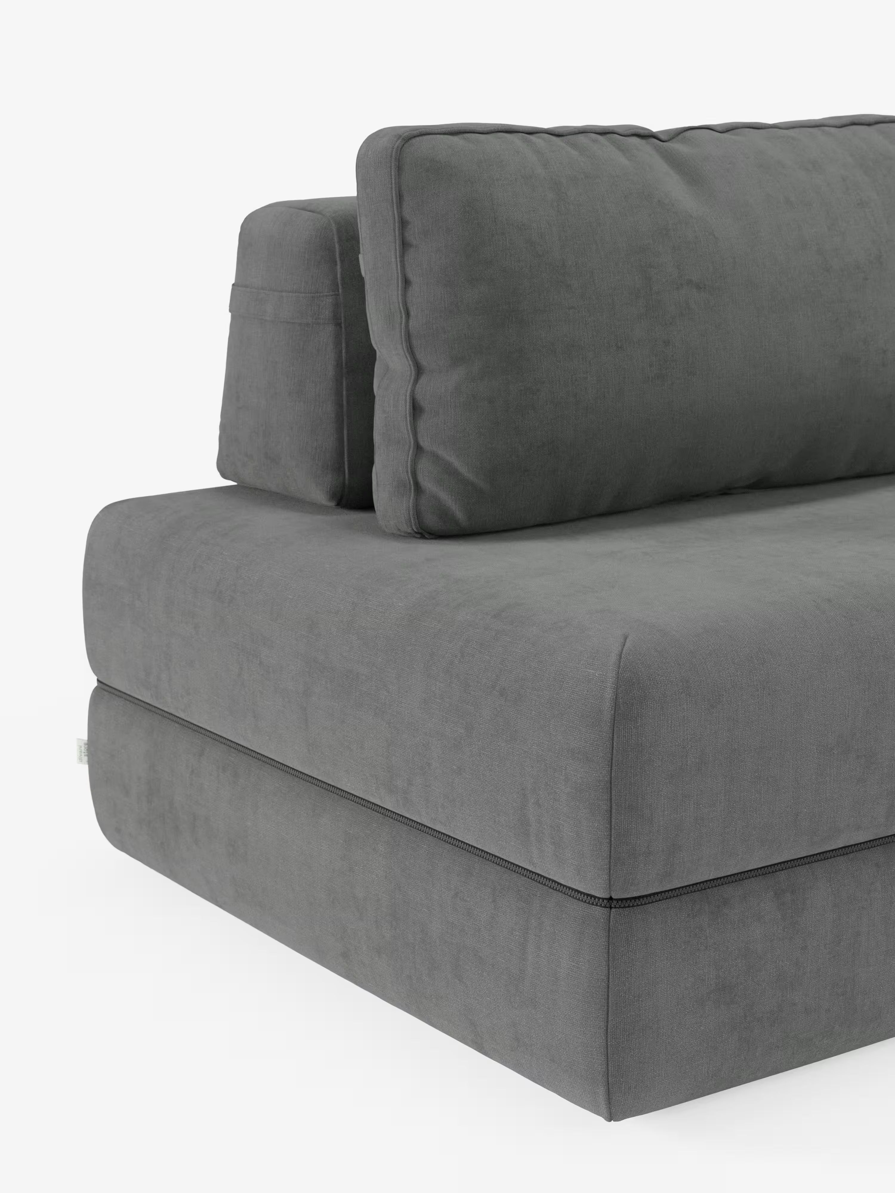 Un primo piano del divano letto matrimoniale Rift a 2 e 3 posti di Divani.Store, realizzato in tessuto T31 grigio scuro smacchiabile, che mette in risalto l’angolo con cuscini di seduta spessi e morbidi e cuscini schienali mobili. Il morbido rivestimento esalta le linee pulite e minimaliste e i delicati dettagli delle cuciture, mentre il materasso in memory foam alto 24 cm garantisce un comfort eccezionale.