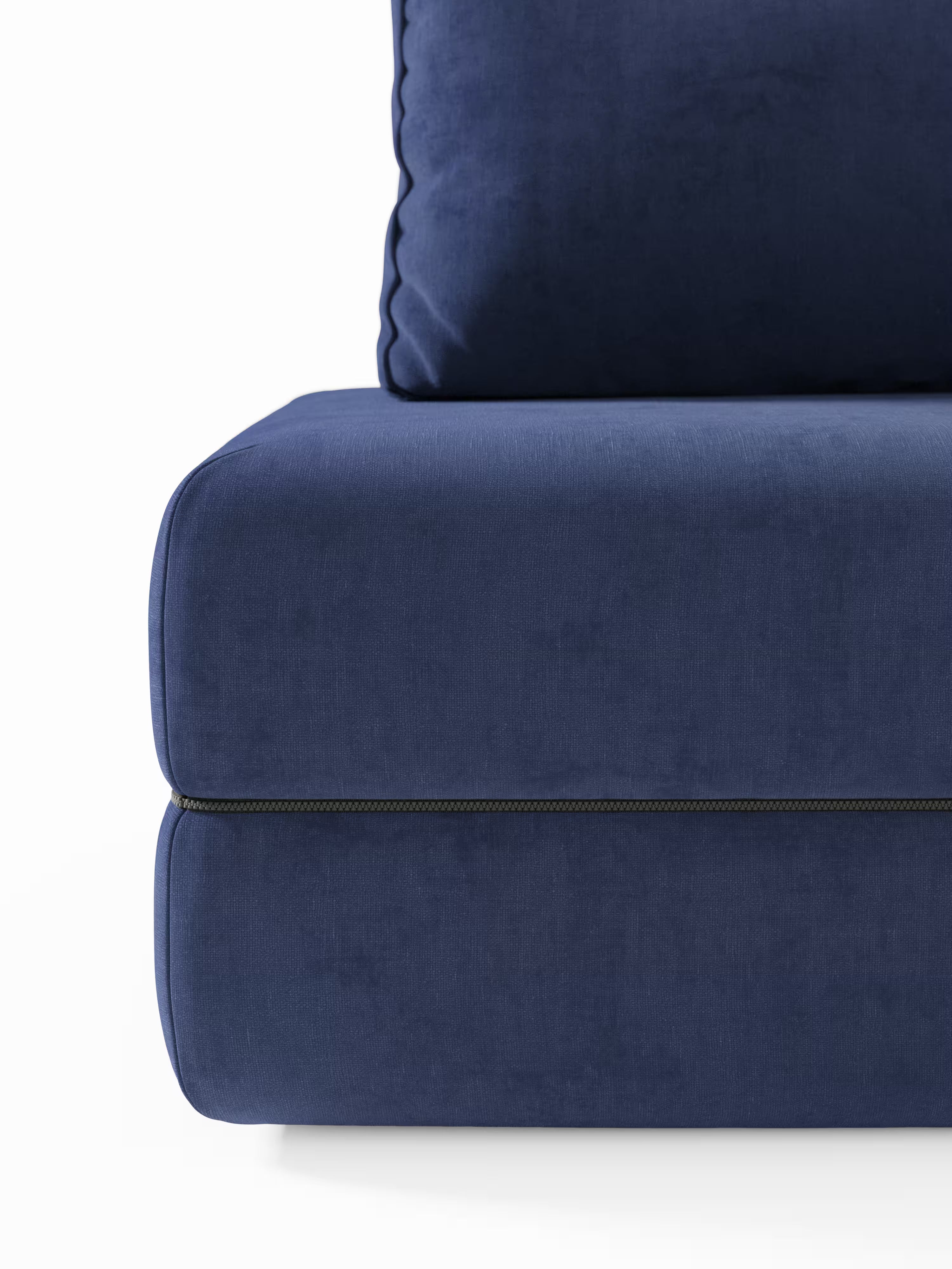 Primo piano del divano letto matrimoniale a 2 posti “Rift” di Divani.Store, rivestito in tessuto blu scuro e dotato di schienali mobili. L’immagine mette in risalto il cuscino della seduta e quello della parte bassa dello schienale, tra i quali è visibile una cucitura a bordino che corre orizzontalmente per accentuare i bordi puliti e ben definiti del divano. Lo sfondo è bianco a tinta unita.
