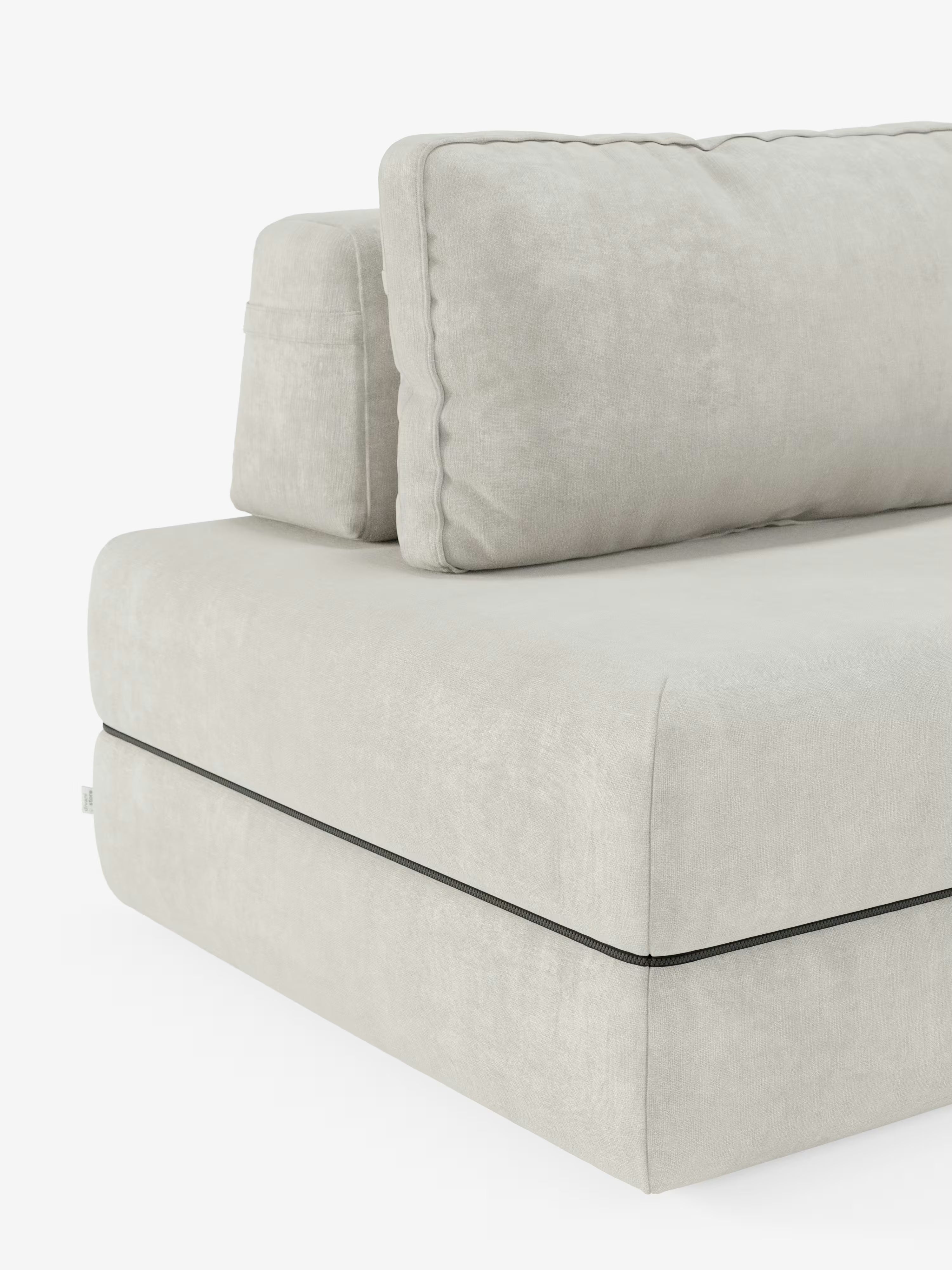 Un primo piano del divano letto matrimoniale Rift a 2 e 3 posti di Divani.Il modello, dotato di schienali regolabili, morbidi cuscini, rivestimento in tessuto T31 morbido e resistente alle macchie color beige chiaro, un materasso in memory foam alto 24 cm e una sottile linea nera che ne sottolinea la base, è presentato su uno sfondo bianco.