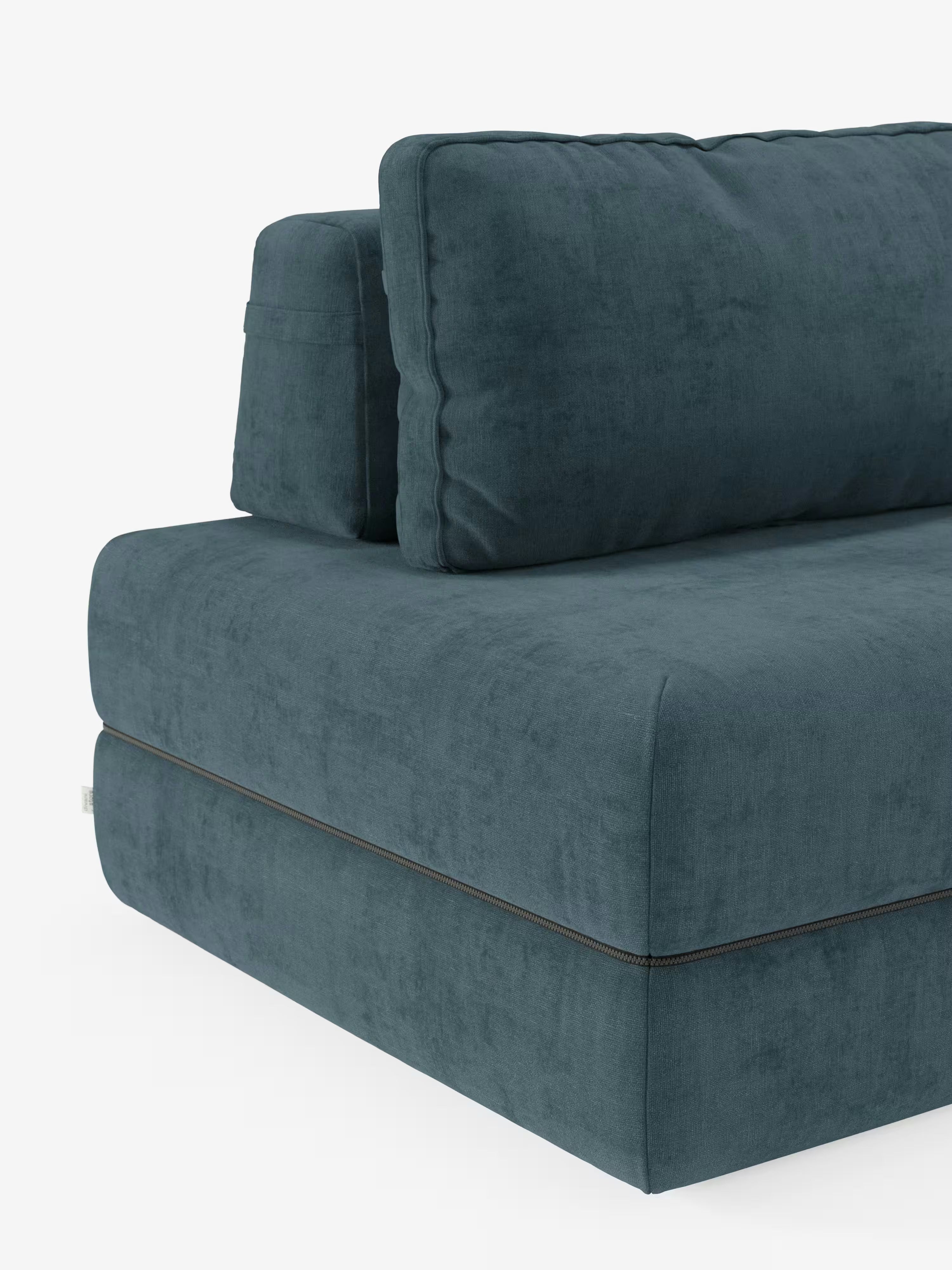Un primo piano del divano letto matrimoniale Rift a 2 e 3 posti di Divani.Store mostra i cuscini spessi della seduta e dello schienale rivestiti in un intenso blu verde acqua, con cuciture a vista che corrono orizzontalmente lungo la base, sottolineandone l’estetica moderna. Il divano, dotato di schienali reclinabili e di un materasso in memory foam alto 24 cm rivestito in tessuto T31 facile da pulire, è fotografato su uno sfondo bianco a tinta unita.