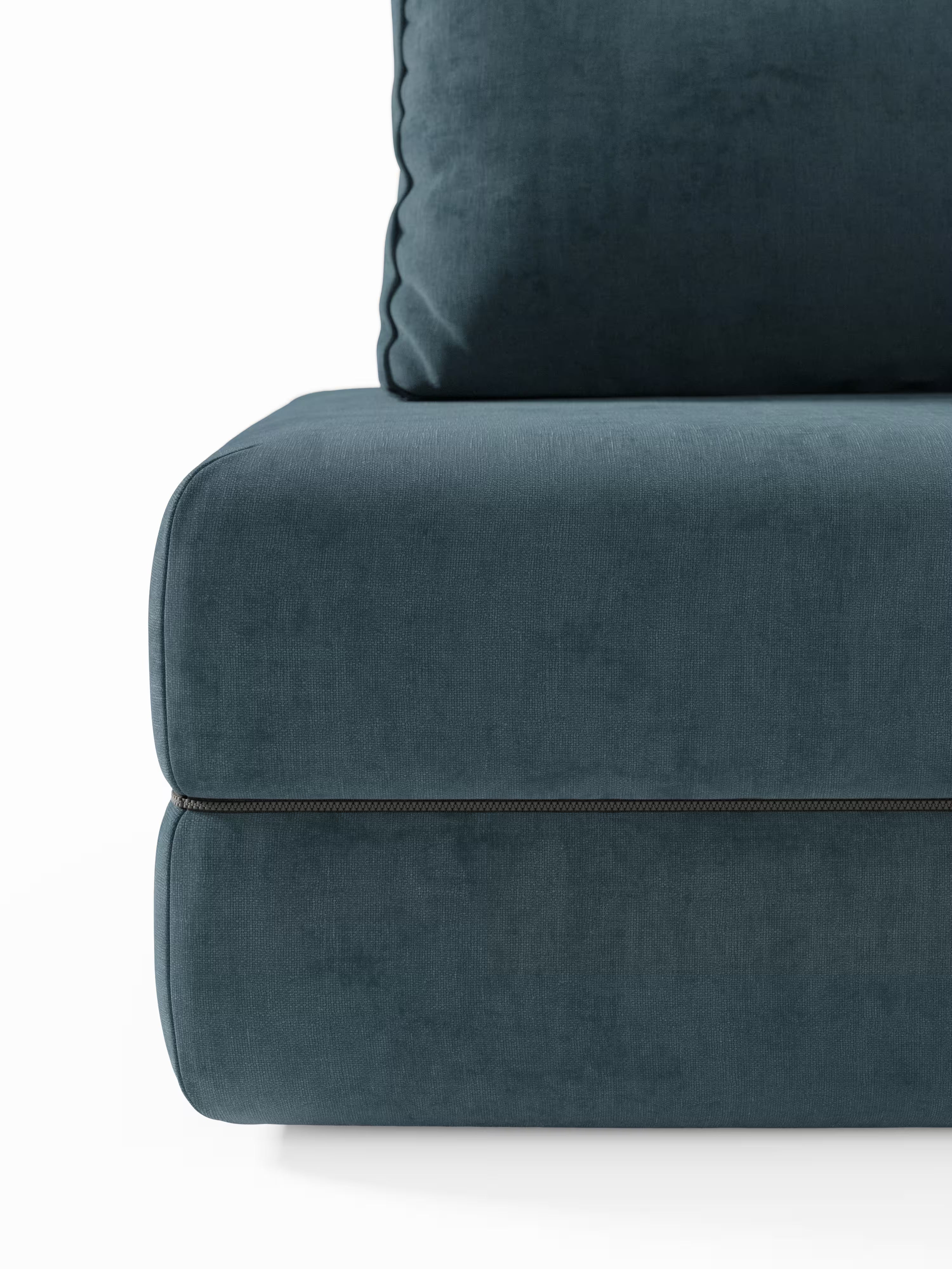 Primo piano dell’angolo inferiore del divano letto matrimoniale Rift di Divani.Store, in tessuto verde acqua scuro, caratterizzato da un cuscino di seduta generosamente imbottito con cucitura a cerniera a vista e da una parte del morbido, dritto, che mettono in risalto le linee slanciate caratteristiche di questo moderno divano letto a 2 o 3 posti con schienali orientabili e un materasso in memory foam alto 22 cm nella versione T31, il tutto su uno sfondo bianco a tinta unita.