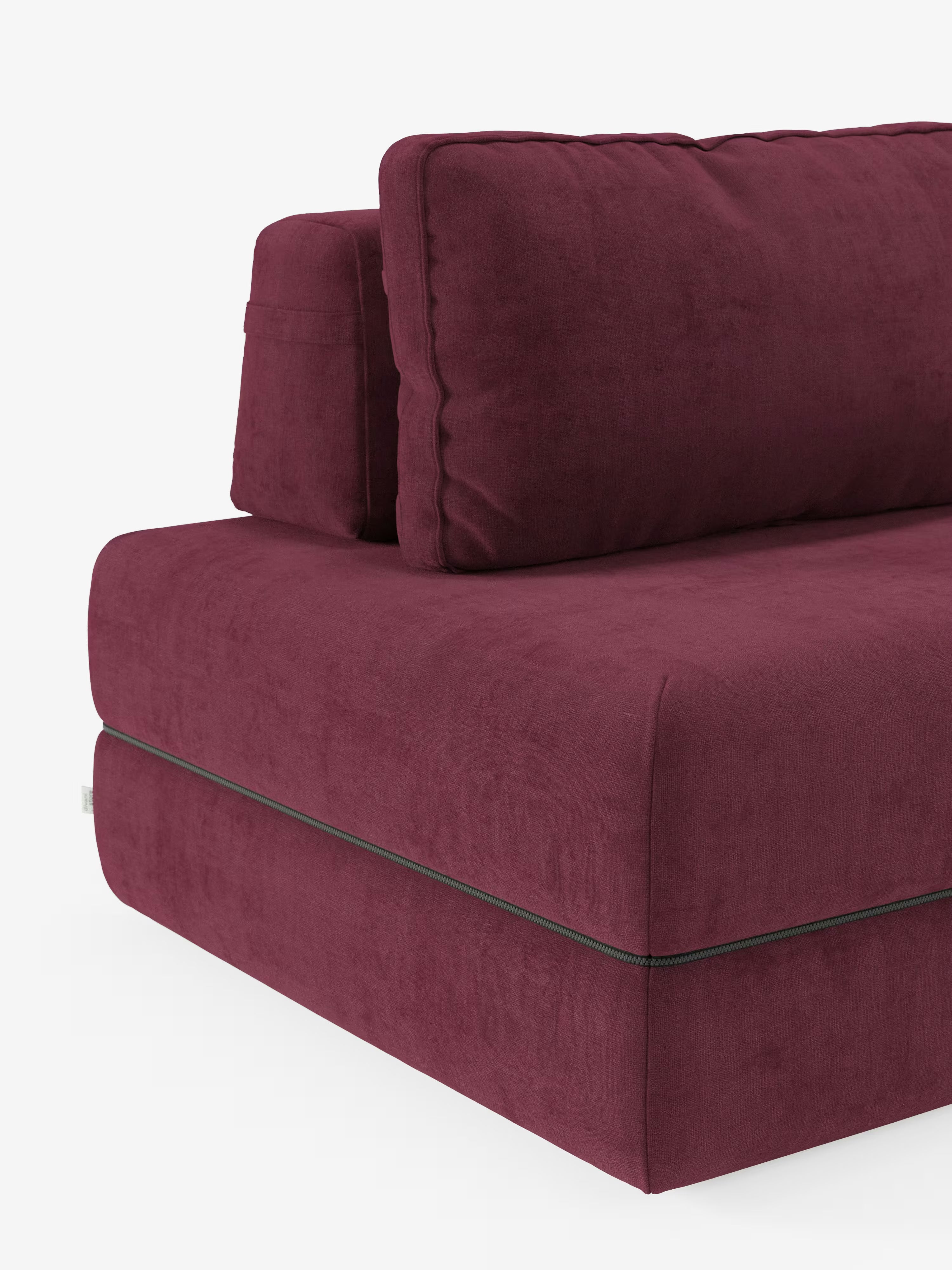 Il divano letto matrimoniale Rift di Divani.Store è ripreso in primo piano, mettendo in risalto il suo tessuto T31 color bordeaux scuro e resistente alle macchie, che ne accentua il design moderno. Il divano presenta una seduta morbida e cuscini dello schienale spessi e rimovibili con cuciture a vista. La sua texture soffice risalta sullo sfondo bianco a tinta unita, mettendo in risalto l’elegante colore e la forma distintiva di questo modello a 2 o 3 posti, dotato di un materasso in memory foam alto 24 cm.