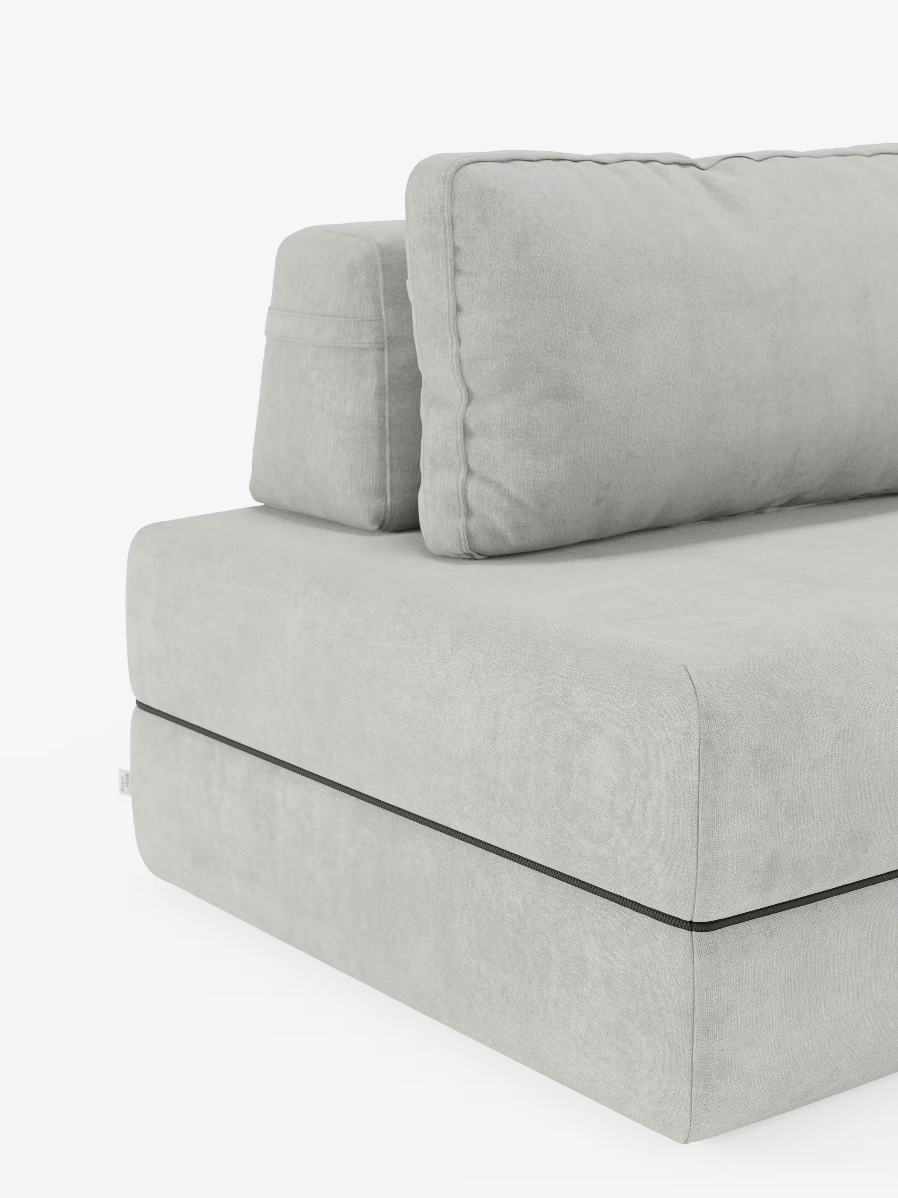 Un primo piano della poltrona letto Rift con materasso alto 24 cm e memory foam di Divani.Store, caratterizzata da un design moderno in tessuto T31 grigio chiaro smacchiabile. L'attenzione è concentrata sull'angolo, che mette in risalto il cuscino di seduta spesso, un ampio cuscino rettangolare per lo schienale con schienale mobile e un cuscino poggiatesta più piccolo. Lo sfondo è bianco a tinta unita.
