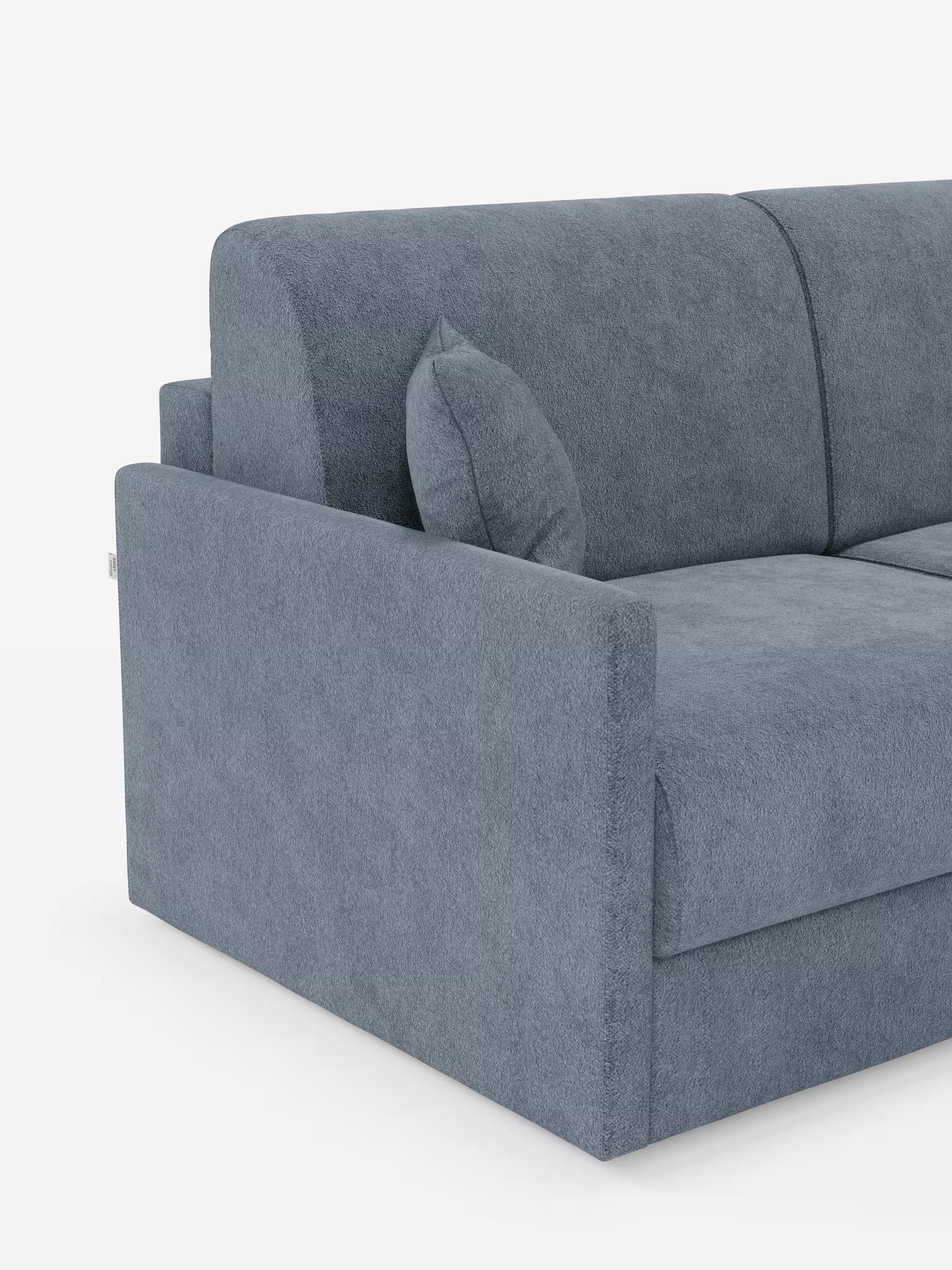 Ecco una vista parziale del divano letto Tommy a 2 e 3 posti matrimoniale di Divani.Store, realizzato in un moderno tessuto T33 blu-grigio, simile al cotone e resistente alle macchie. Il divano presenta linee pulite, minimaliste e contemporanee con braccioli e schienale a vista, accompagnati da un piccolo cuscino rettangolare abbinato. Interamente sfoderabile al 100% per una facile manutenzione, il design risalta su uno sfondo bianco per enfatizzare il rivestimento testurizzato e l’estetica elegante.