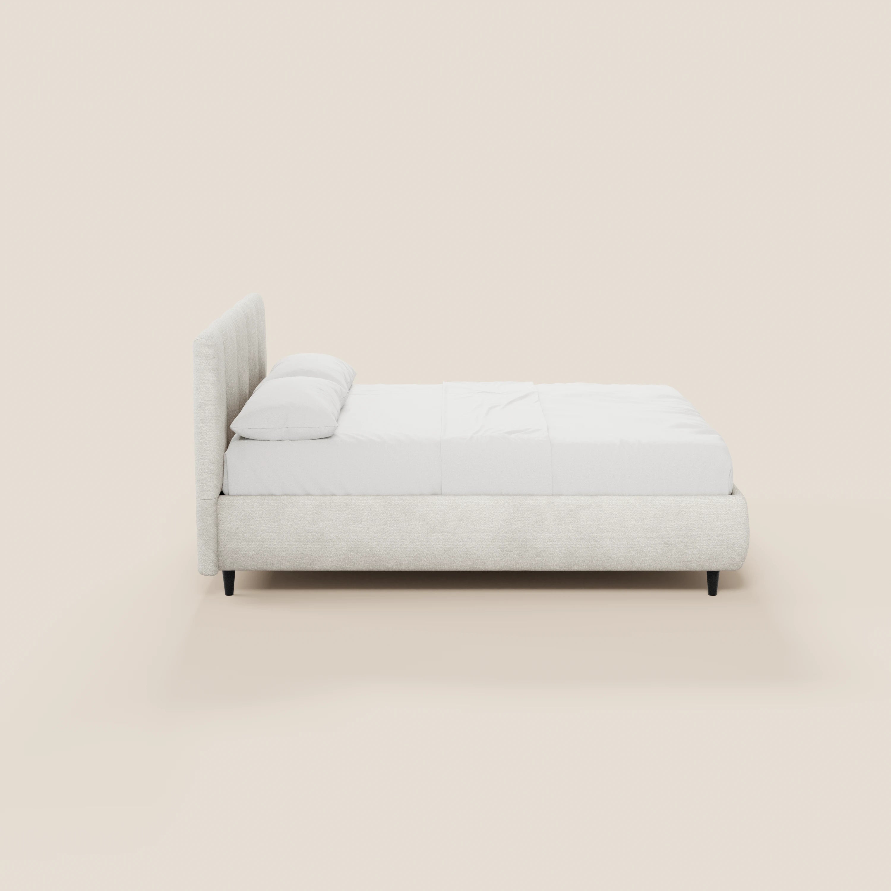 Una vista laterale minimalista del letto imbottito ARKAM con contenitore e testiera a lavorazione verticale di Letti.store mette in risalto il suo tessuto chiaro certificato Oeko-Tex® e le gambe corte e scure in stile shabby chic, che risaltano su uno sfondo bianco sporco.