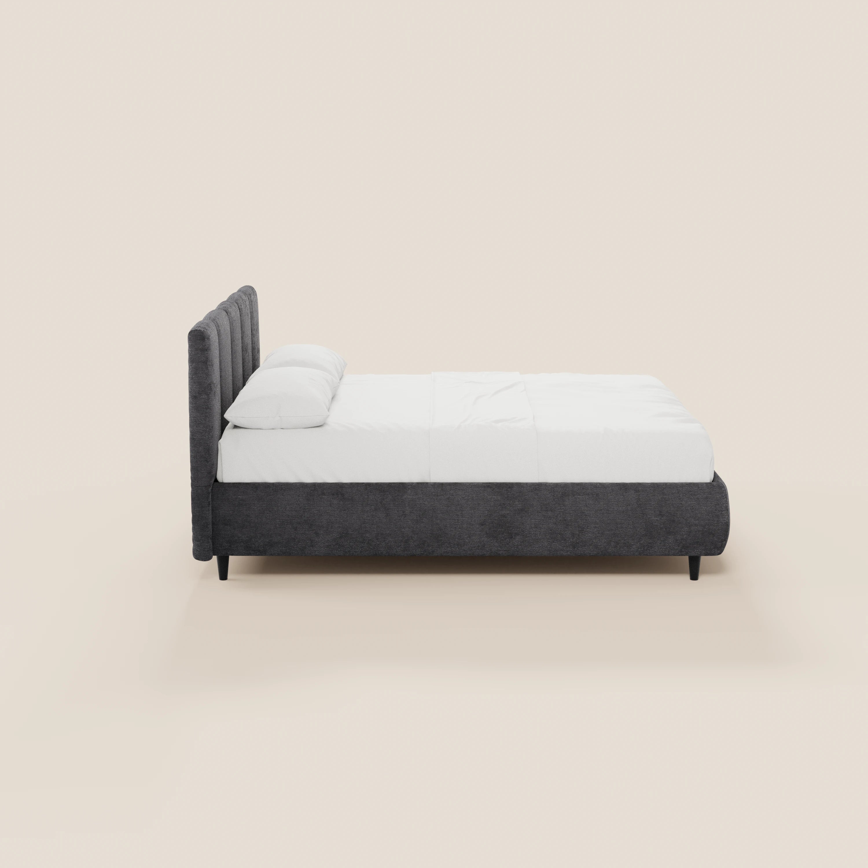 Il letto imbottito ARKAM di Letti.store, dotato di vano contenitore e testiera verticale rivestita in tessuto Oeko-Tex®, è raffigurato di profilo con biancheria da letto bianca e due cuscini, su quattro gambe nere, su uno sfondo beige chiaro.