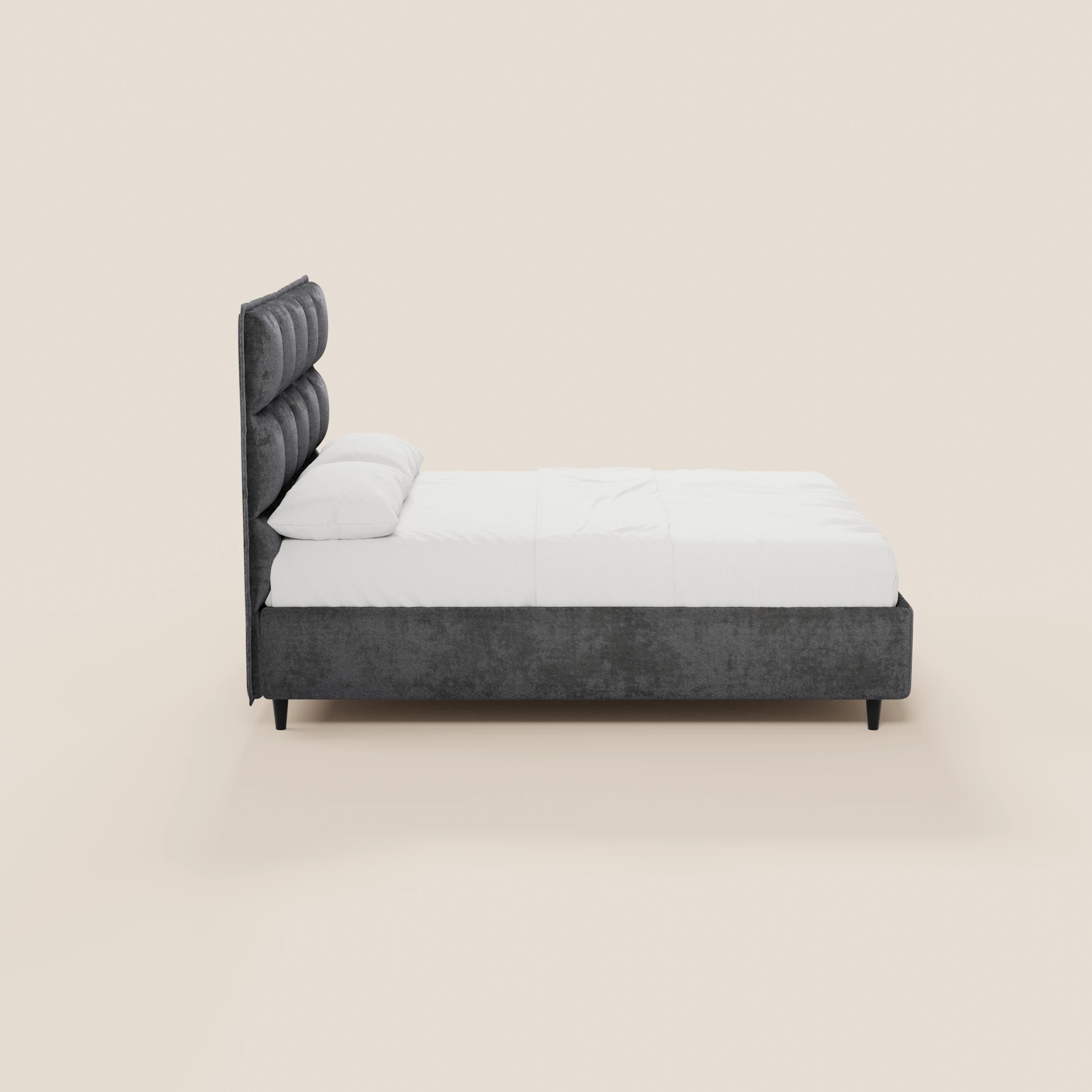 Vista laterale del letto imbottito AURO con contenitore e testiera alta capitonné in ciniglia Oeko-Tex® di Letti.store, caratterizzato da una testiera alta imbottita di colore grigio scuro, biancheria da letto bianca, due cuscini, gambe corte nere e design minimalista.