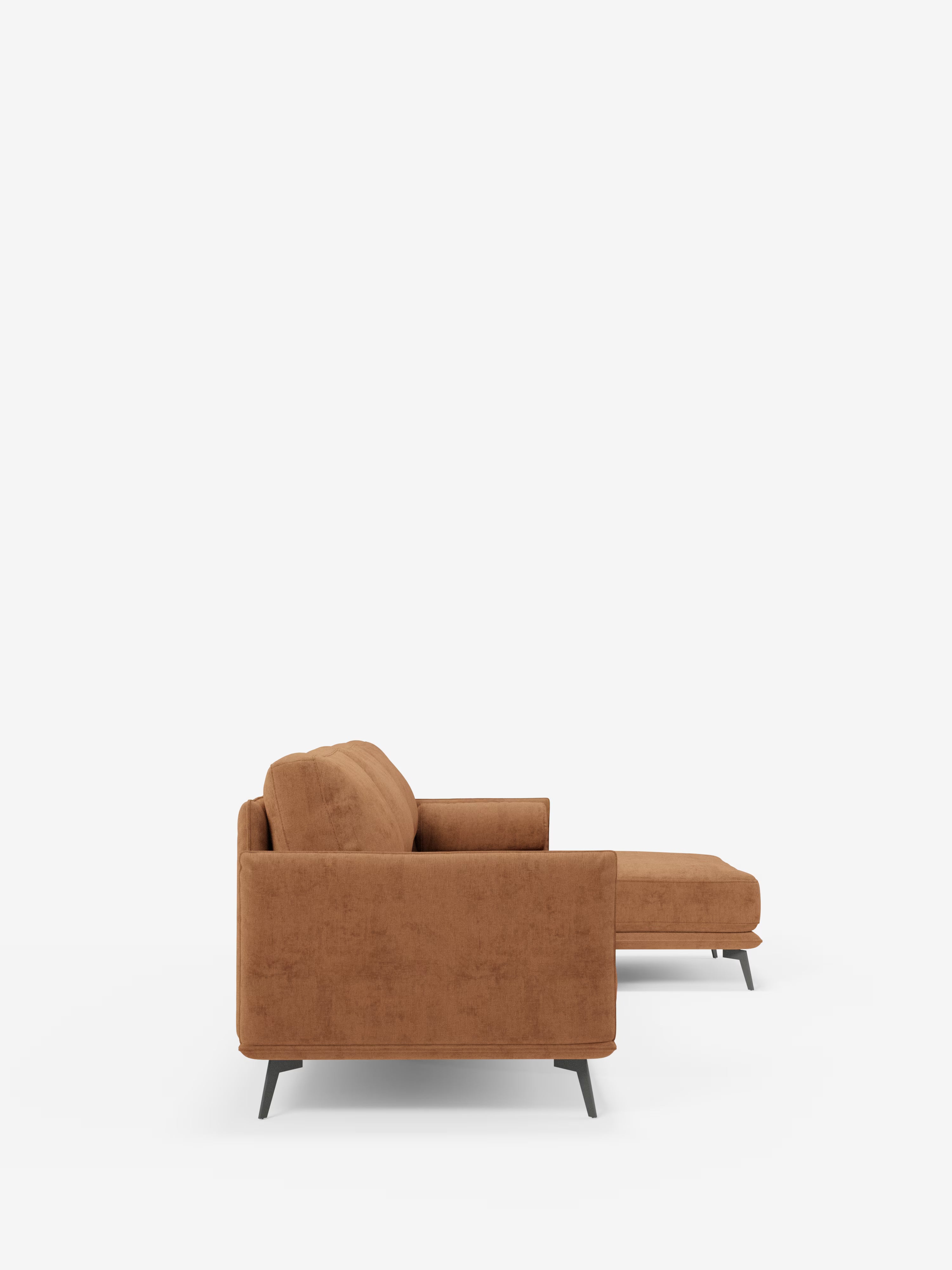 Vista laterale del “Basalto Divano moderno angolare con penisola” di Divani.Il negozio espone un divano componibile contemporaneo di colore marrone con chaise longue rivolta verso destra: questo elegante modello si caratterizza per le linee pulite, i cuscini dello schienale e della seduta dal profilo basso imbottiti in piuma, i braccioli squadrati e la base angolare in metallo nero; è rivestito in tessuto T31 antimacchia e presentato su uno sfondo bianco a tinta unita.