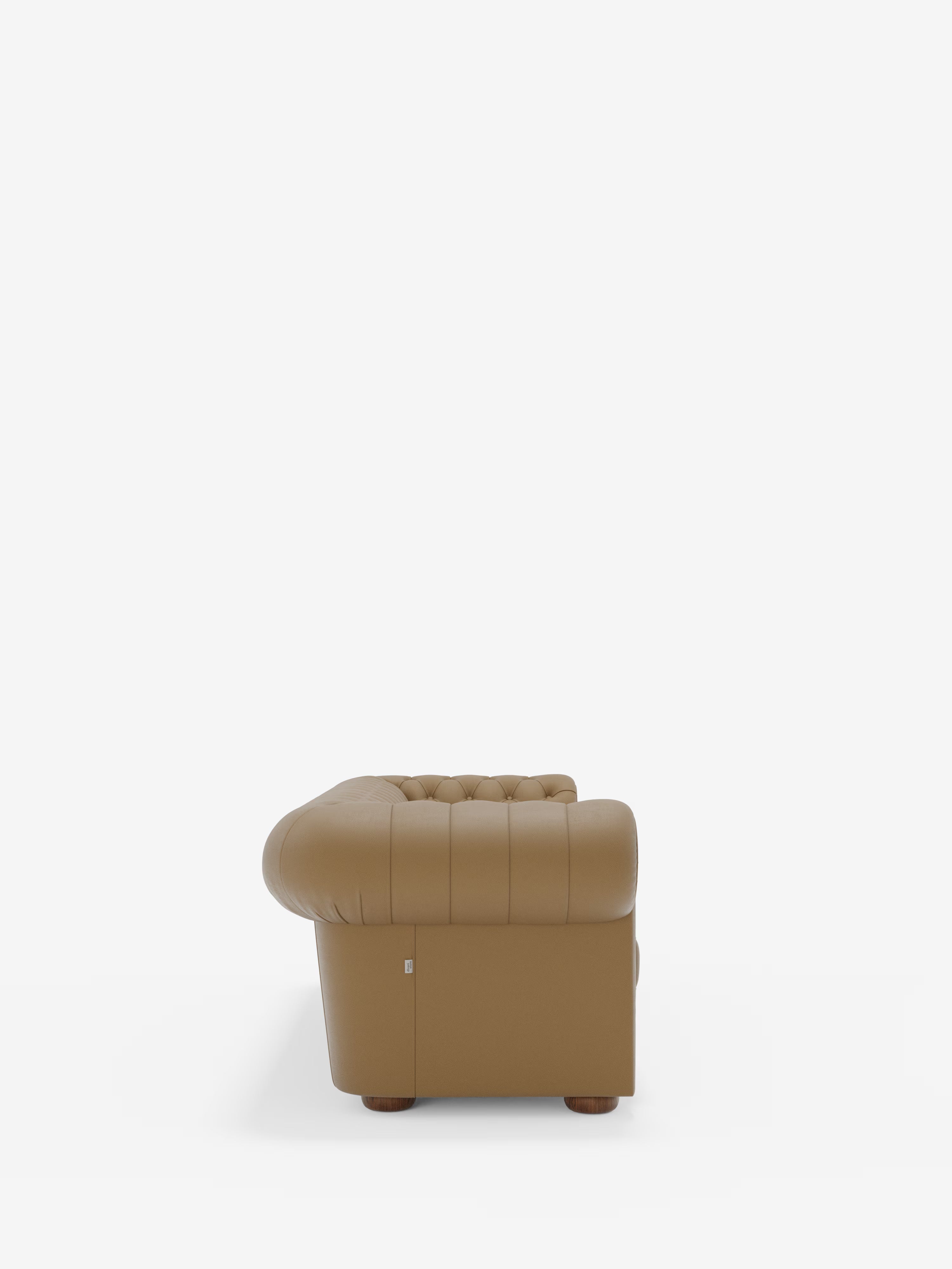Vista laterale del Chester 4 Posti 3 sedute in Vera Pelle – Chesterfield Capitonné Artigianale di Divani.Store, un divano artigianale in pelle marrone caratterizzato da uno schienale capitonné e braccioli arrotondati, su uno sfondo bianco a tinta unita. Realizzato in vera pelle, questo divano poggia su piccole gambe rotonde in legno, che ne sottolineano il design lussuoso e strutturato.