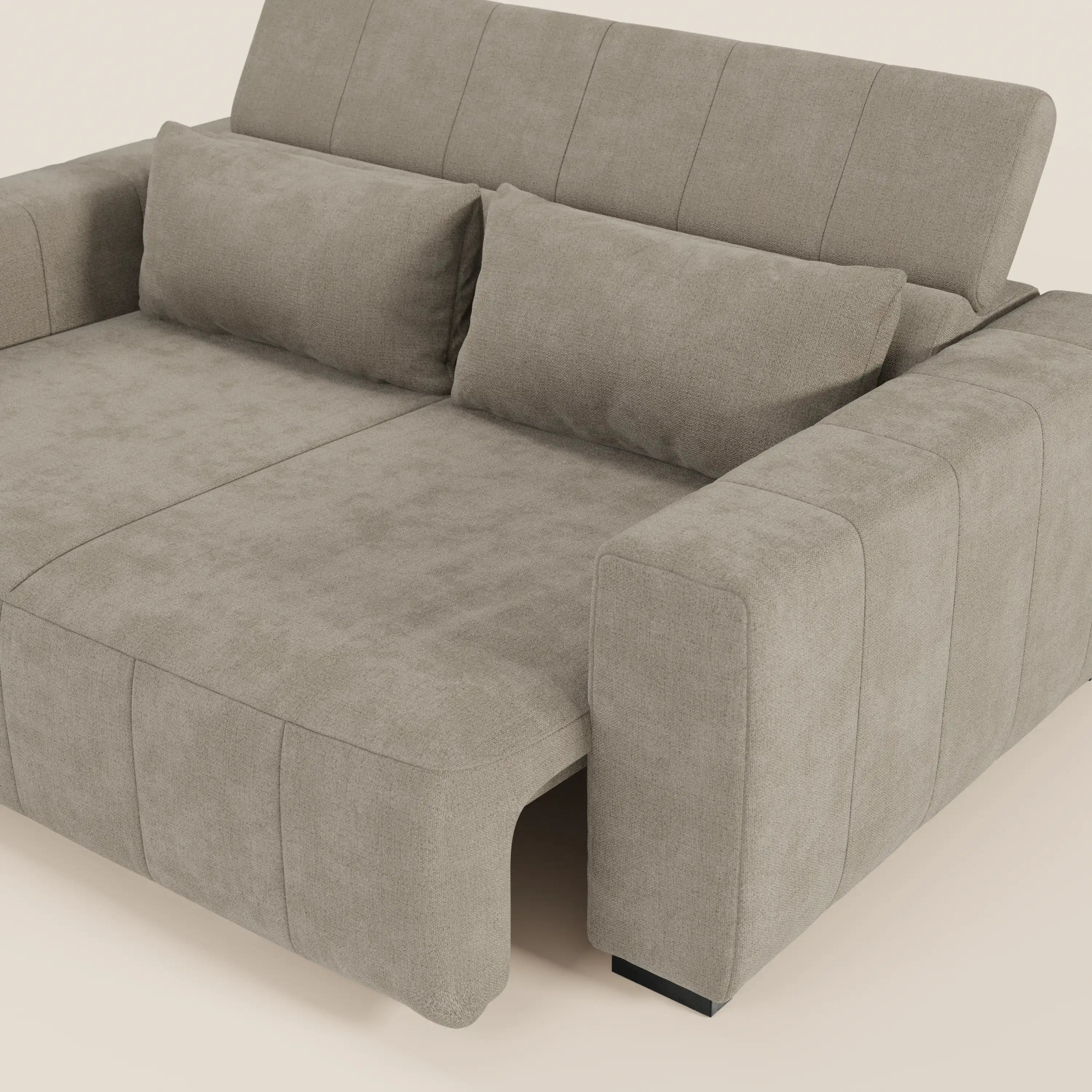 Il divano Doric 3 posti di Divani.Store è caratterizzato da ampi braccioli, due cuscini rettangolari per lo schienale, dettagli cuciti, sedute allungabili con relax elettrico e poggiatesta reclinabili, il tutto in tessuto T23 antimacchia su uno sfondo beige chiaro.