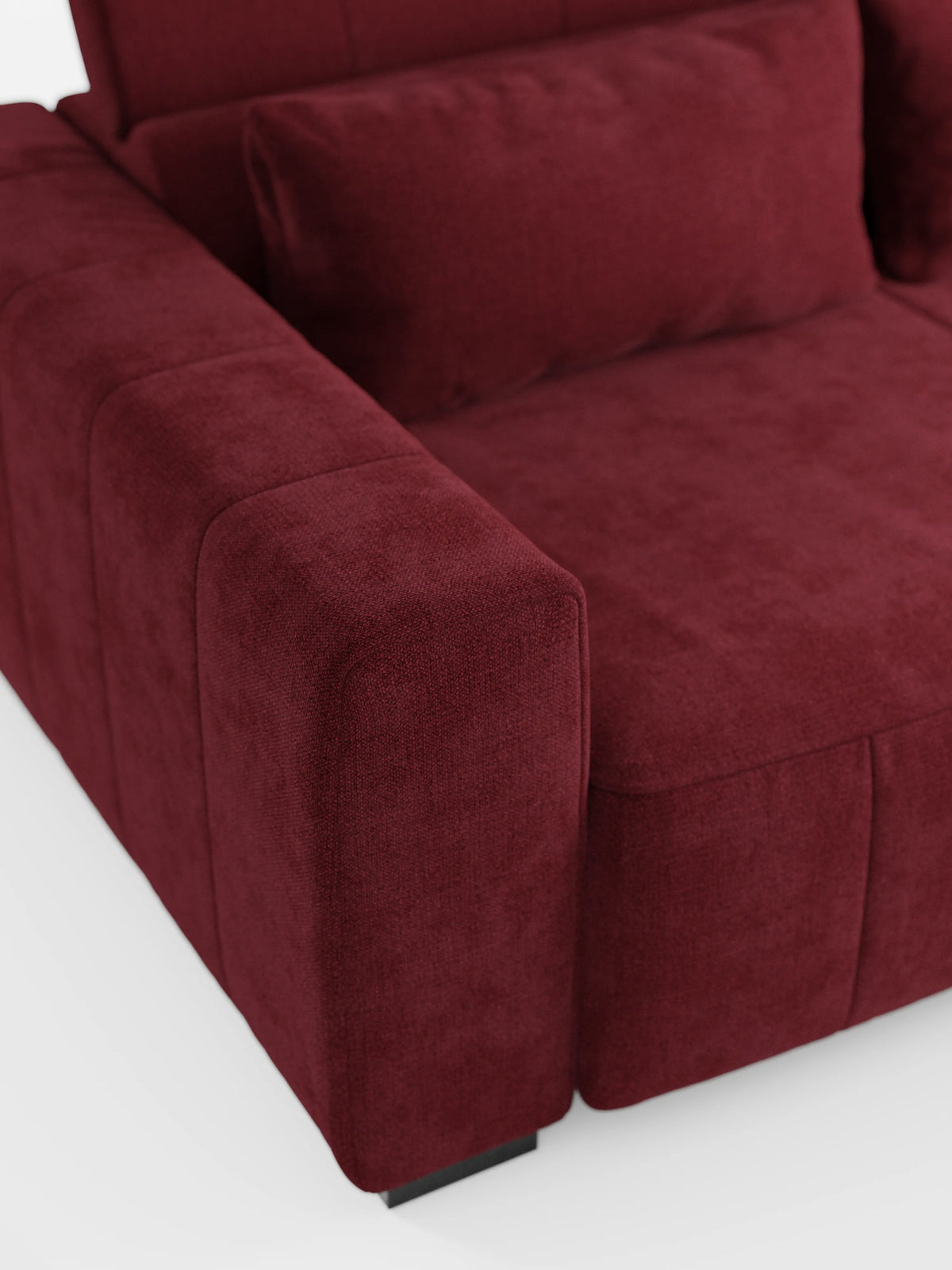 Primo piano del divano angolare Doric con penisola e sedute allungabili con funzione relax elettrica di Divani.Store, presentato in tessuto T23 rosso intenso smacchiabile. L’immagine mette in risalto il bracciolo sinistro, il cuscino di seduta e un cuscino dello schienale abbinato, evidenziandone la morbida trama che ne esalta il comfort lussuoso. Con i poggiatesta reclinabili e i piedini neri bassi, questo divano moderno si staglia con eleganza su uno sfondo bianco.