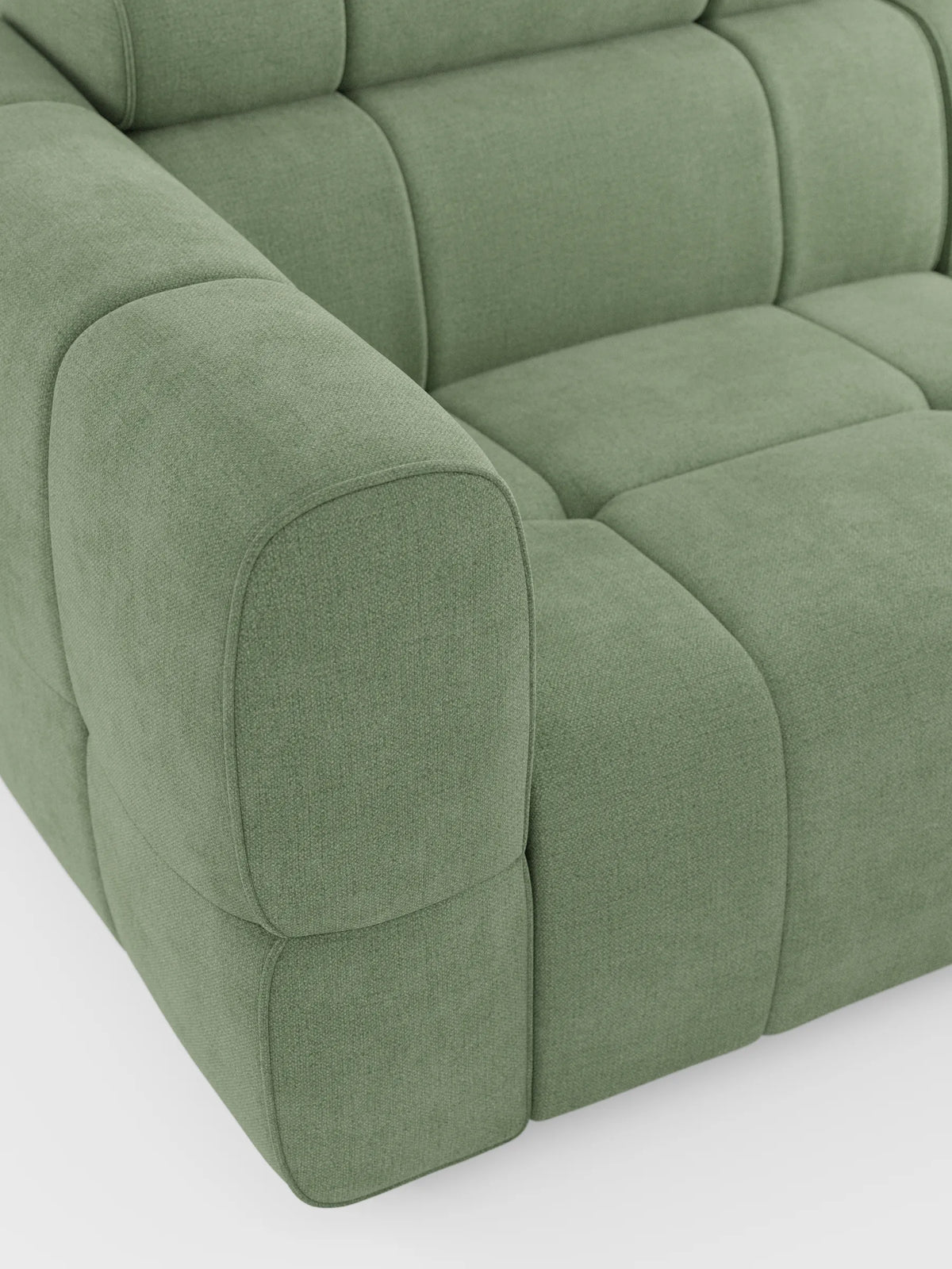 Un primo piano del divano modulare Giotto a 4 posti in verde salvia, con poggiatesta reclinabili e funzione relax elettrica opzionale, rivestito in tessuto smacchiabile T23, caratterizzato da cuscini spessi con pannelli quadrati e braccioli arrotondati su uno sfondo bianco a tinta unita.