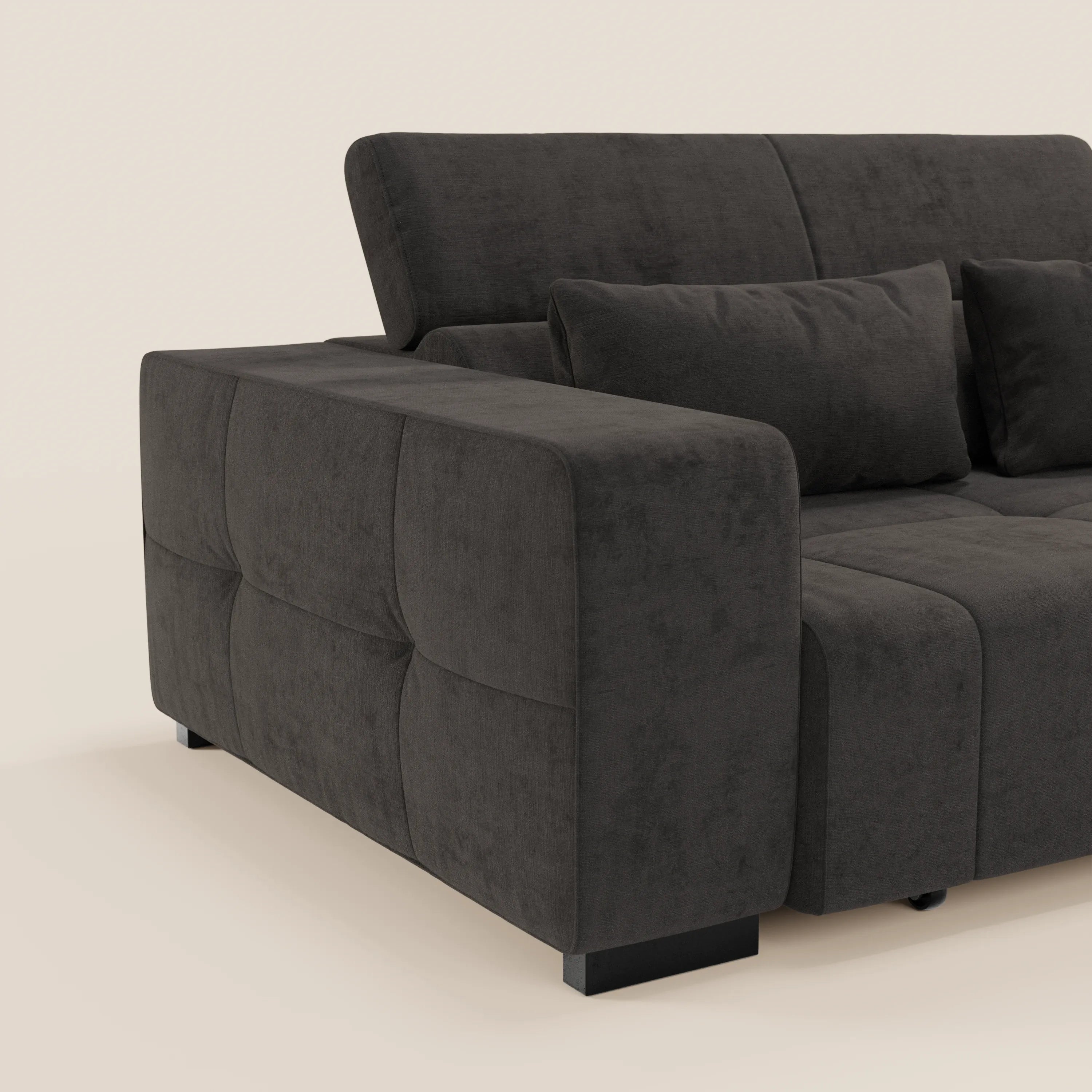 Primo piano del Monarch Divano angolare con penisola e Relax Elettrico di Divani.Store, caratterizzato da braccioli squadrati, cuscini morbidi, poggiatesta reclinabili e morbido tessuto smacchiabile T31 in grigio scuro su sfondo beige chiaro.