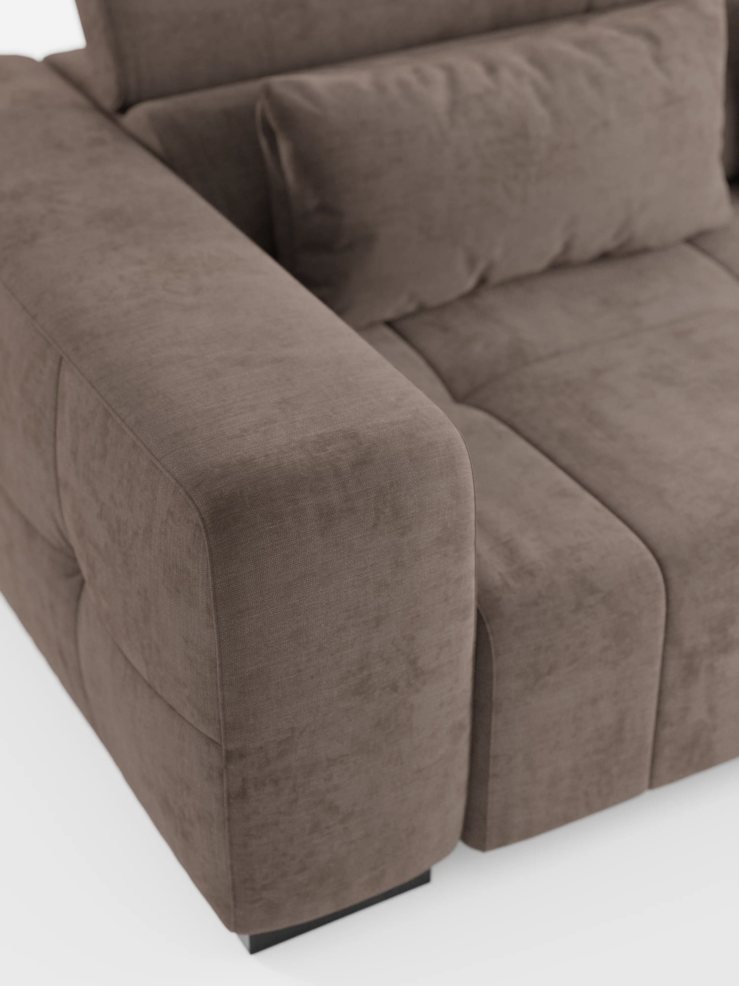 Primo piano del divano angolare Monarch con penisola e funzione Relax Elettrico per l’allungamento delle sedute di Divani.Store, dotato di poggiatesta reclinabili in morbido tessuto T31 resistente alle macchie. L’immagine mette in risalto i cuscini dei braccioli, della seduta e dello schienale, caratterizzati da una texture soffice, cuciture a vista e linee pulite. Il divano poggia su piedini neri corti su uno sfondo bianco.