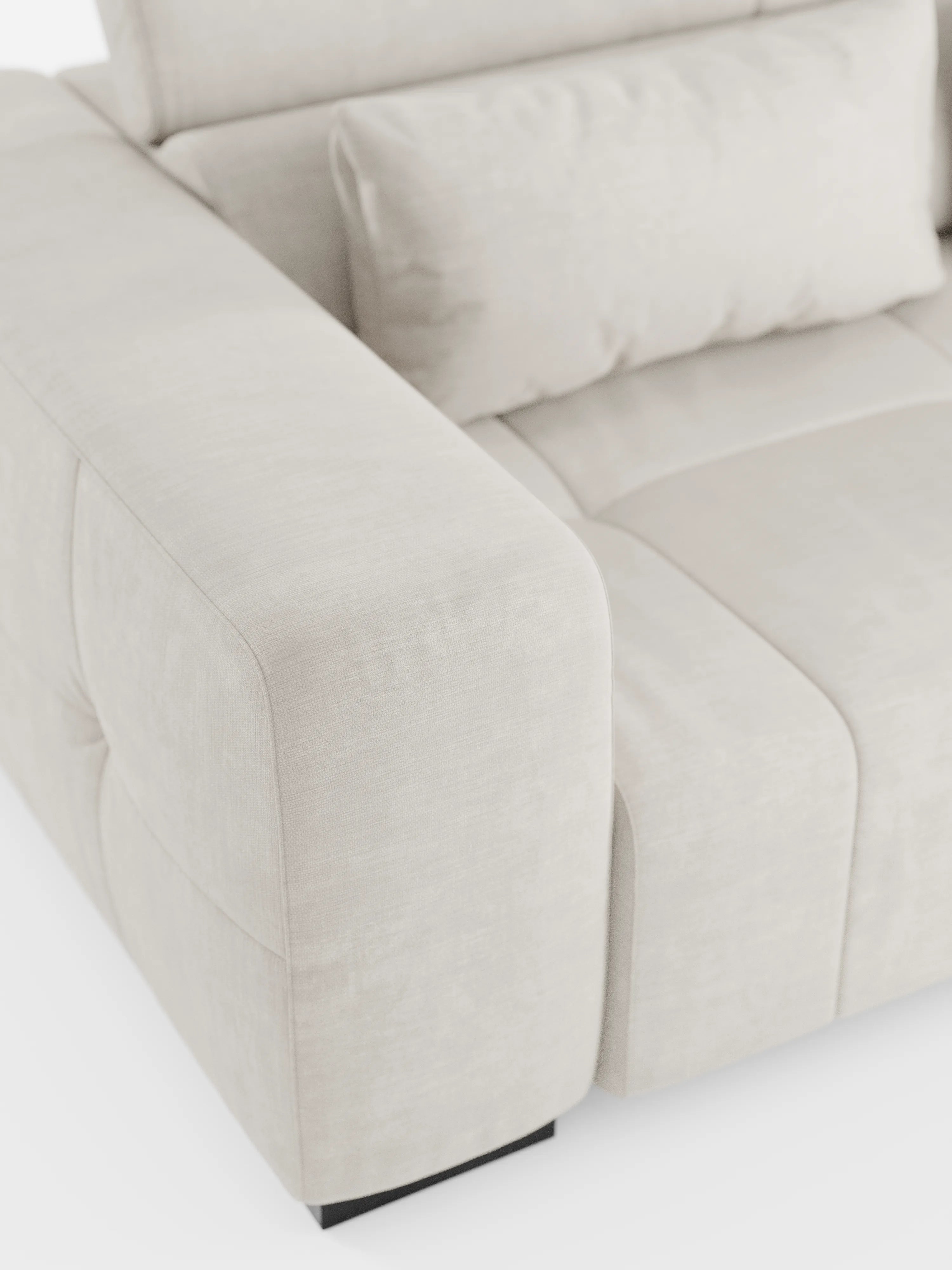 Primo piano del divano angolare Monarch con penisola e sistema Relax elettrico per l’allungamento delle sedute di Divani.Store, rivestito in morbido tessuto T31 resistente alle macchie. Questo moderno divano color beige chiaro presenta ampi braccioli imbottiti, morbidi cuscini dello schienale con cuciture a vista e poggiatesta regolabili. Ispirato al design italiano dei divani relax elettrici, poggia su gambe corte di colore scuro e si distingue per la sua texture accogliente e il fascino contemporaneo.