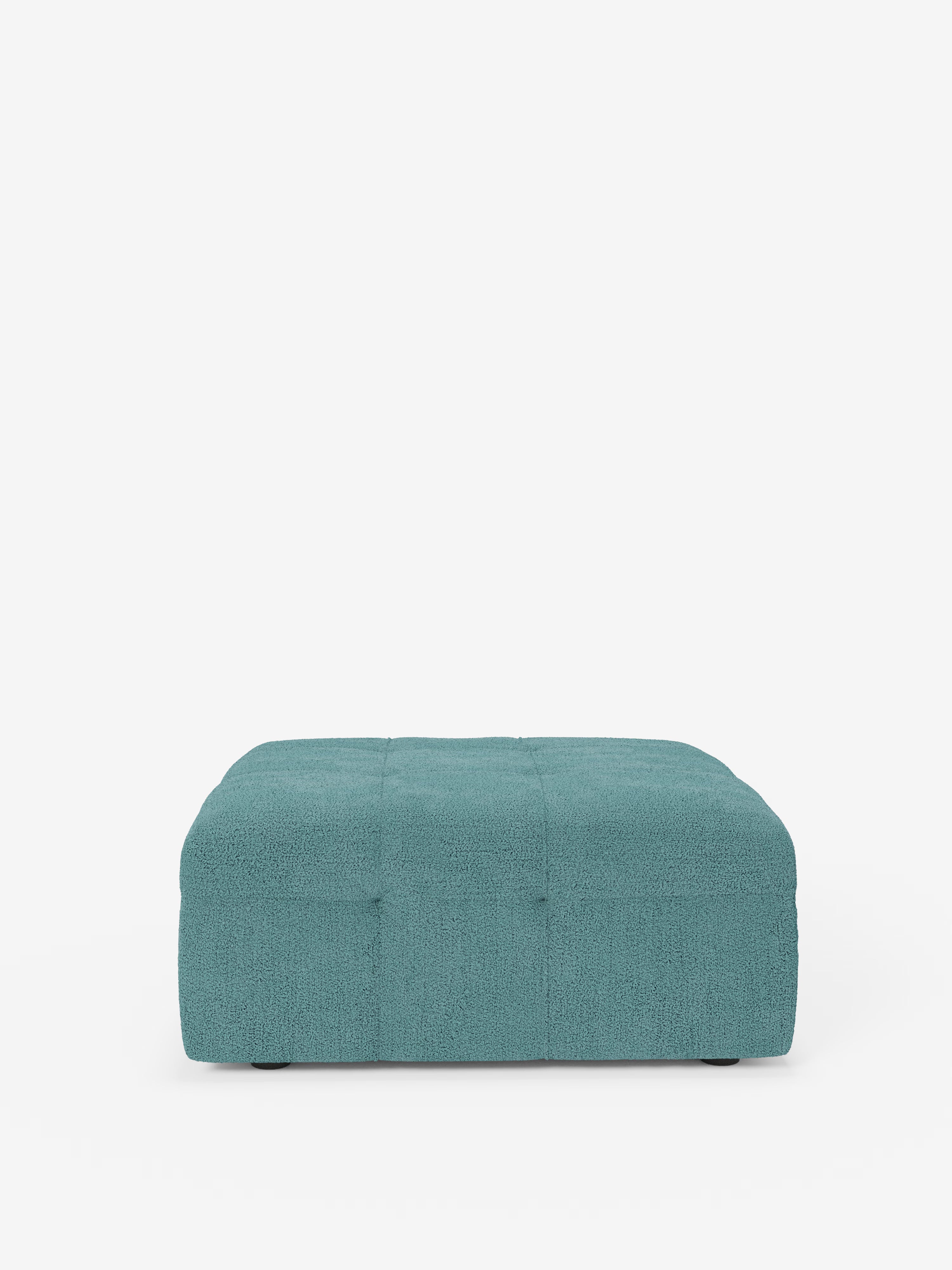 Un pouf e modulo quadrato della linea Mosaic di Divani.Store, color verde acqua, che misura 96x77 cm, è rivestito in tessuto bouclé T21 antimacchia con un motivo capitonné a trama in rilievo. Realizzato con maestria in Italia, questo pouf moderno presenta un profilo ribassato senza gambe visibili su uno sfondo bianco liscio.
