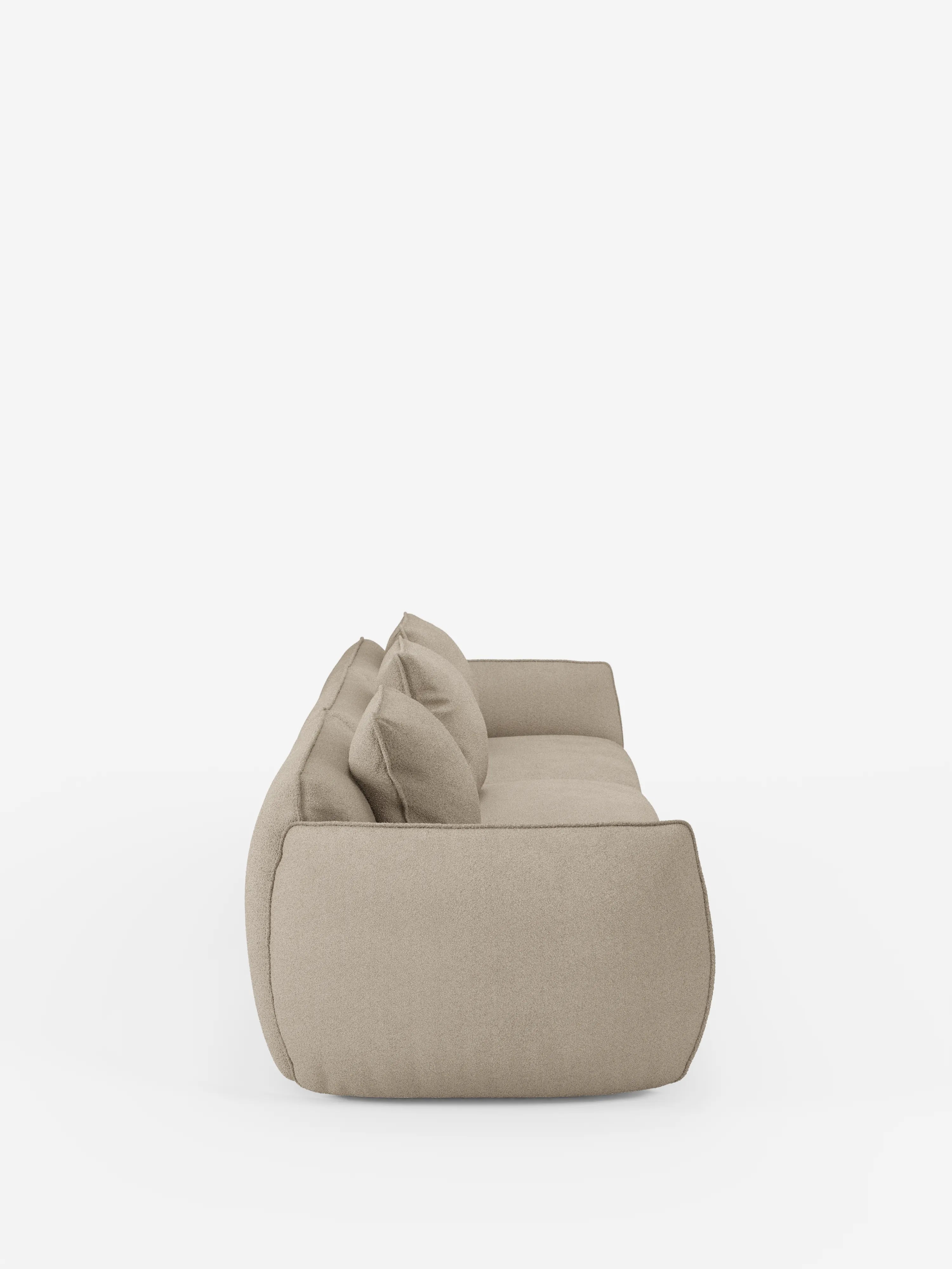 Vista laterale del divano modulare a 3 posti Nimbus di Divani.Store, rivestito in un tessuto morbido e antimacchia con finitura effetto cotone (T33) color beige. Questo moderno divano componibile è caratterizzato da due ampi cuscini di seduta, morbidi cuscini dello schienale e braccioli arrotondati e imbottiti, che conferiscono all’insieme un aspetto morbido e accogliente. Immagine ripresa su uno sfondo bianco a tinta unita.
