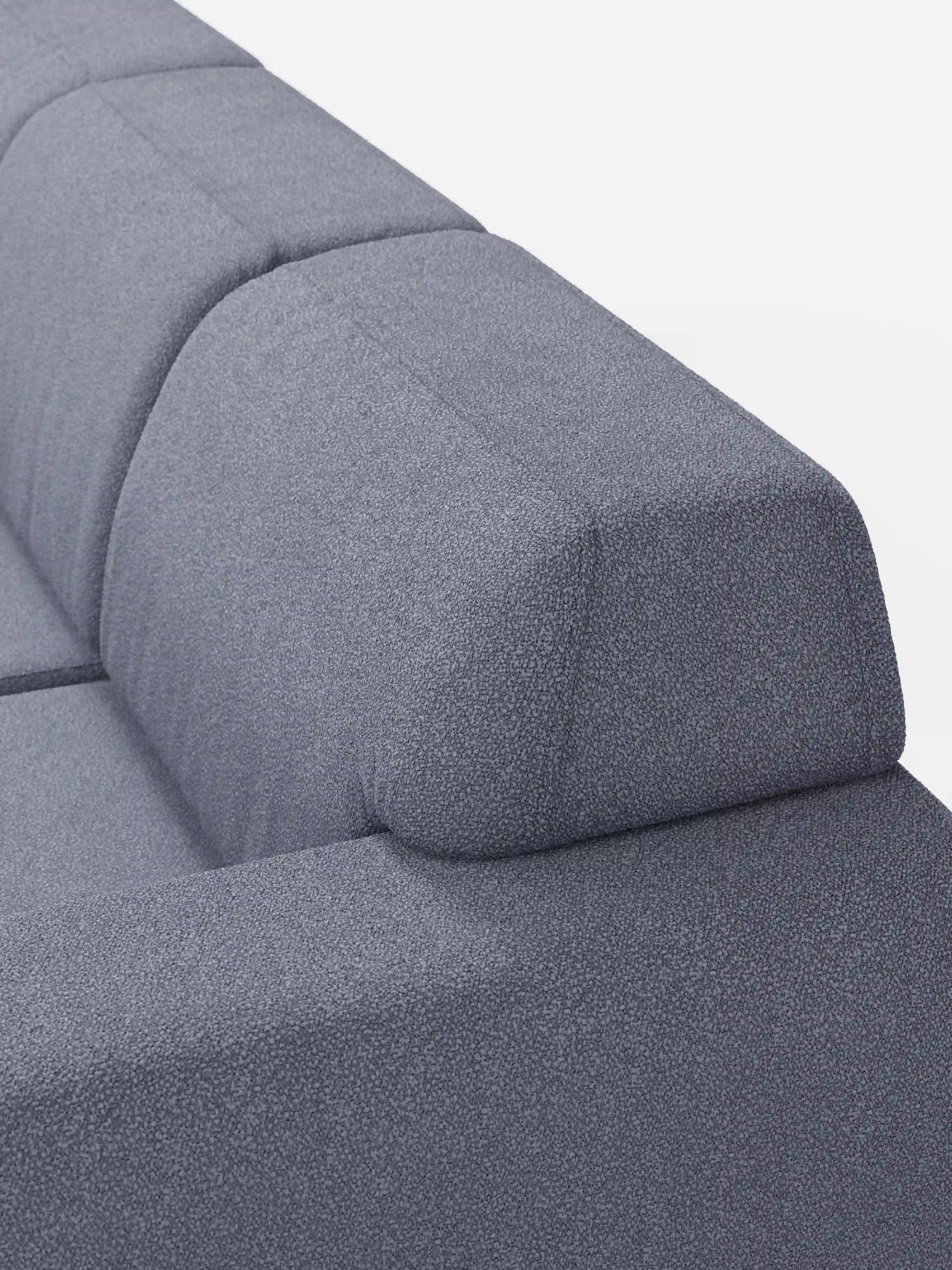Primo piano del divano Orbit con 3 sedute scorrevoli e allungabili in tessuto effetto cotone smacchiabile T33 di Divani.Store, caratterizzato da un rivestimento grigio moderno con un motivo raffinato e strutturato. Il design minimalista comprende uno schienale e un poggiatesta angolari e geometrici ed è completamente sfoderabile per una facile manutenzione. Le linee pulite e dritte risaltano su uno sfondo bianco a tinta unita.
