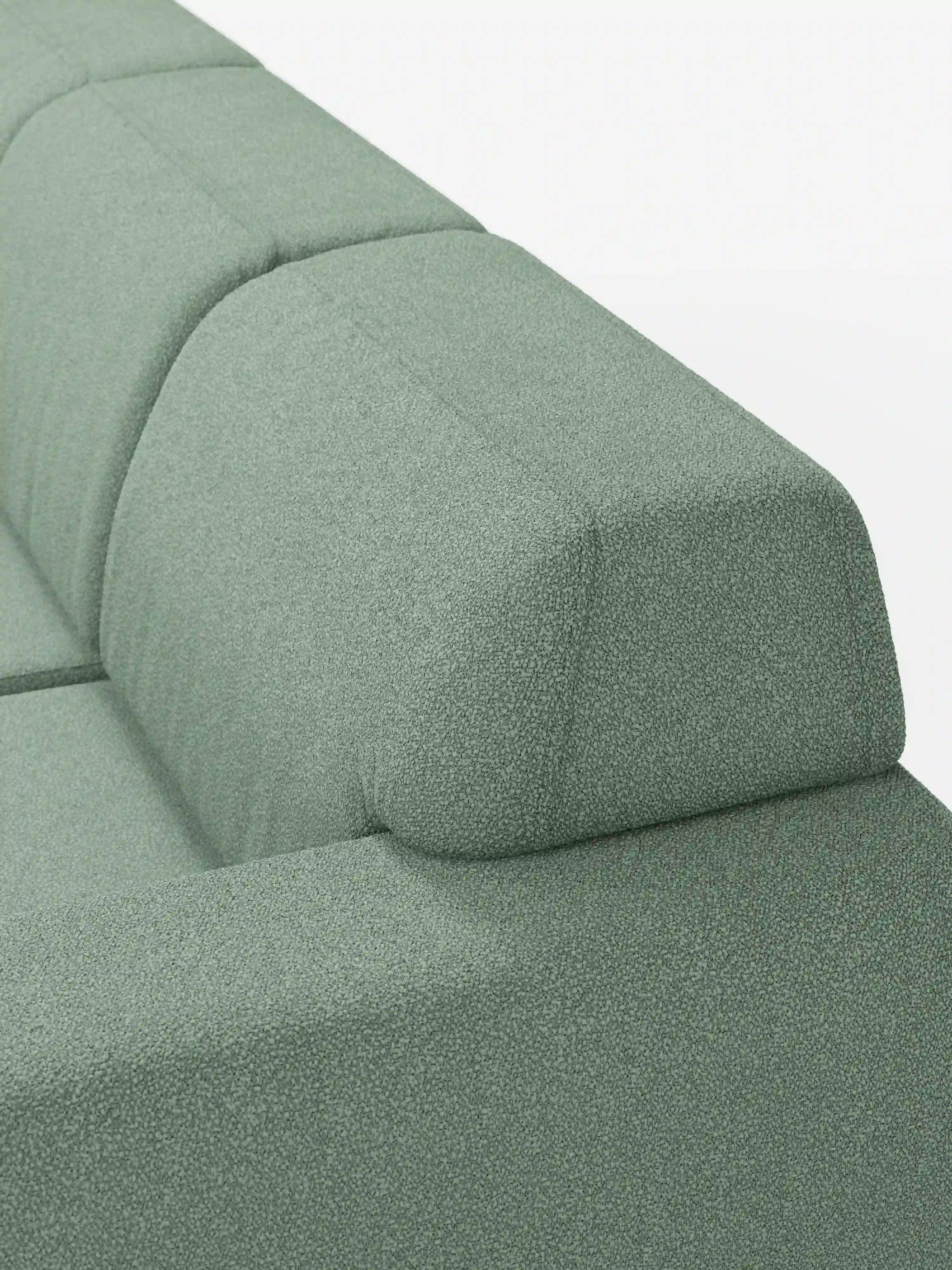 Primo piano del divano Orbit con 3 sedute scorrevoli ed estensibili in tessuto effetto cotone smacchiabile T33 di Divani.Store, che mette in risalto il rivestimento verde chiaro e testurizzato ed evidenzia le linee pulite e spigolose dello schienale e del poggiatesta. L’immagine mette in risalto la forma geometrica della parte superiore del divano su uno sfondo bianco. Dotato di tre sedute scorrevoli e allungabili in modo indipendente, questo divano offre il massimo in termini di comfort e flessibilità.