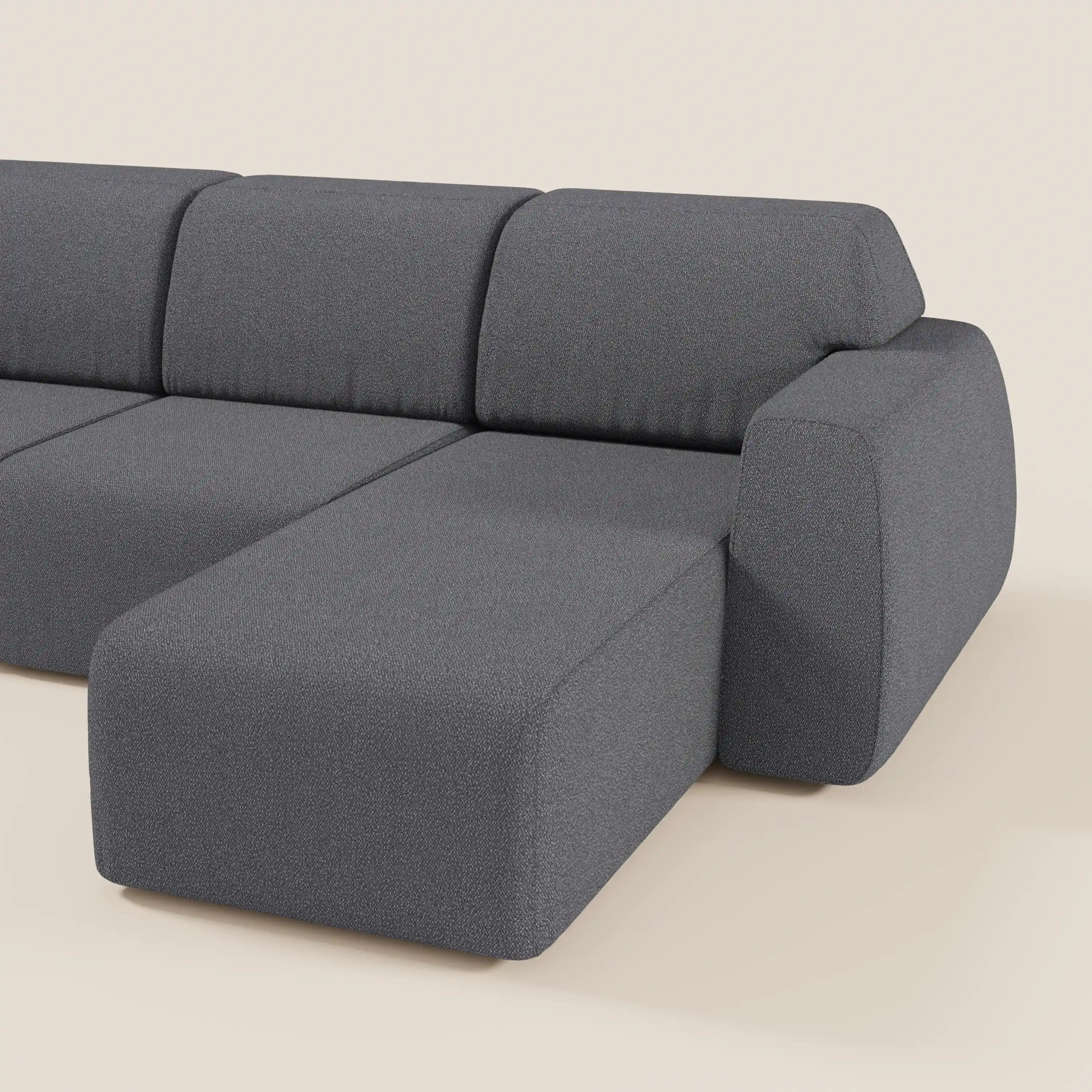 Il divano angolare Orbit con penisola reversibile e sedute allungabili di Divani.Store, in tessuto smacchiabile effetto cotone T33 grigio scuro, presenta ampi cuscini e chaise lounge destra su sfondo beige chiaro senza altri oggetti visibili.