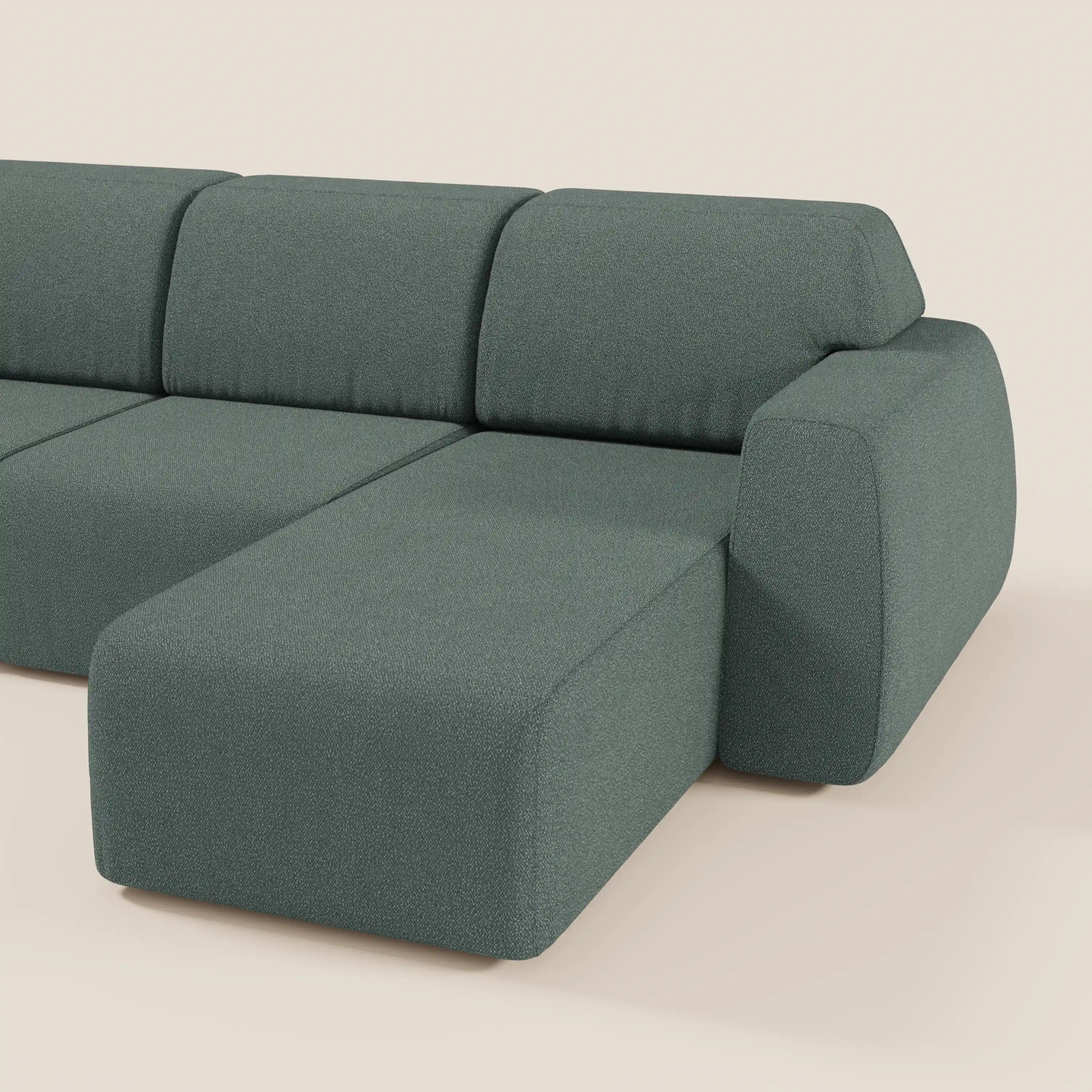 Il divano angolare Orbit con penisola reversibile di Divani.Store, in tessuto smacchiabile effetto cotone T33 verde tenue, ha tutte le sedute allungabili, profilo basso, ampio bracciolo destro e linee geometriche su sfondo beige chiaro.