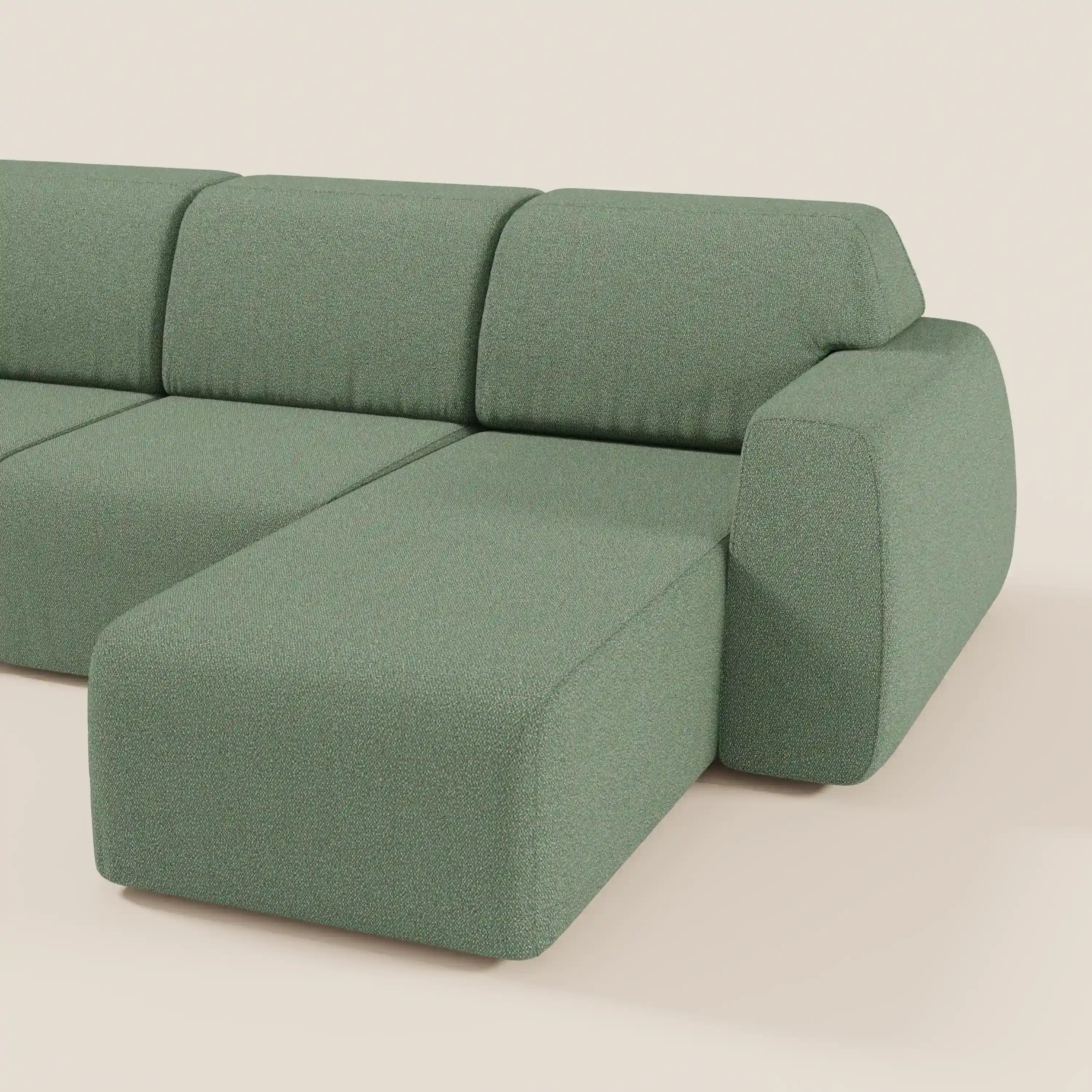 Il divano angolare Orbit di Divani.Store è caratterizzato da una chaise reversibile, sedute allungabili e tessuto effetto cotone smacchiabile verde salvia, su uno sfondo beige neutro.