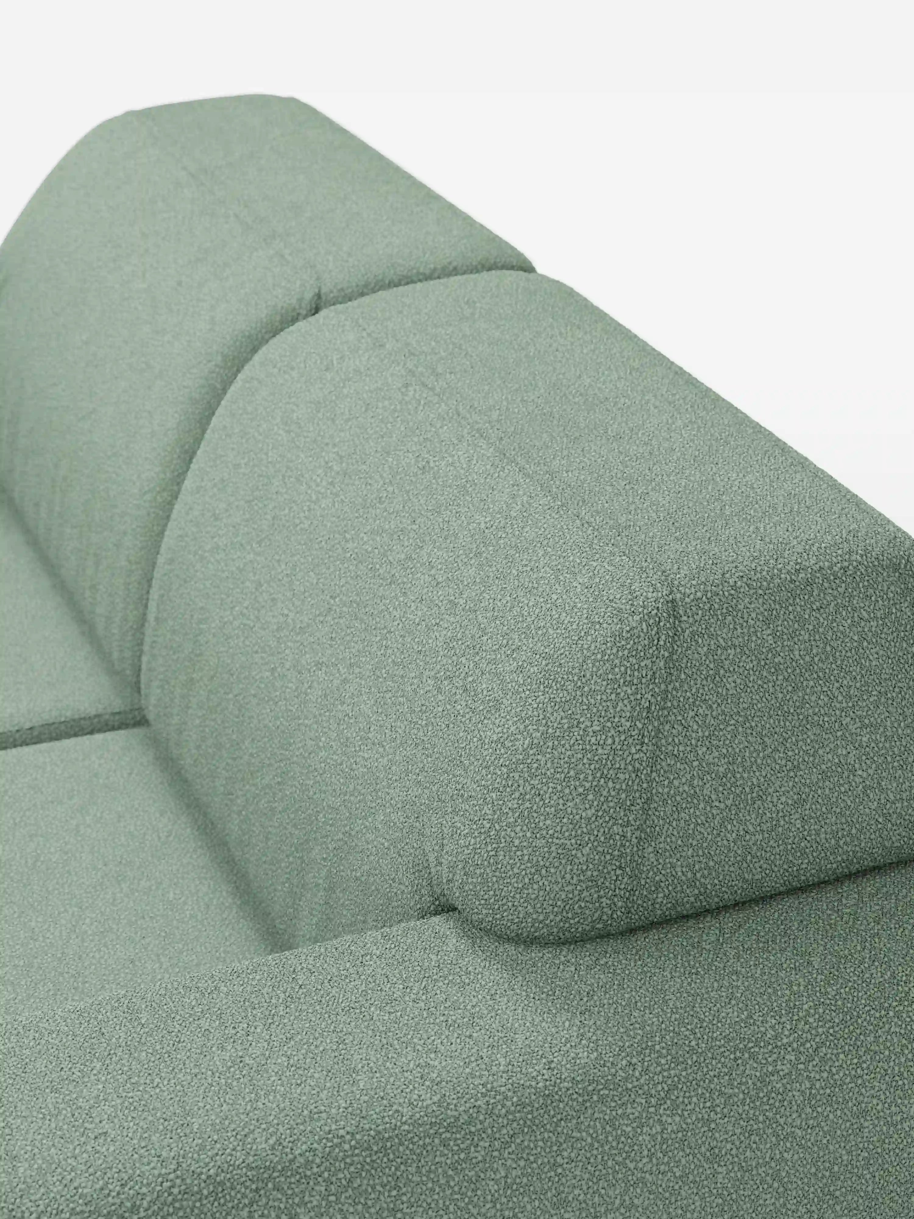 Primo piano del divano Orbit a 2 e 3 posti con sedute scorrevoli di Divani.Store, rivestito in tessuto T33 verde salvia effetto cotone, resistente alle macchie. Questo divano moderno è dotato di rivestimenti completamente sfoderabili e si caratterizza per un rivestimento morbido e soffice dalle linee semplici e pulite. Su uno sfondo bianco, il colore del divano e la trama del tessuto sono i veri protagonisti.