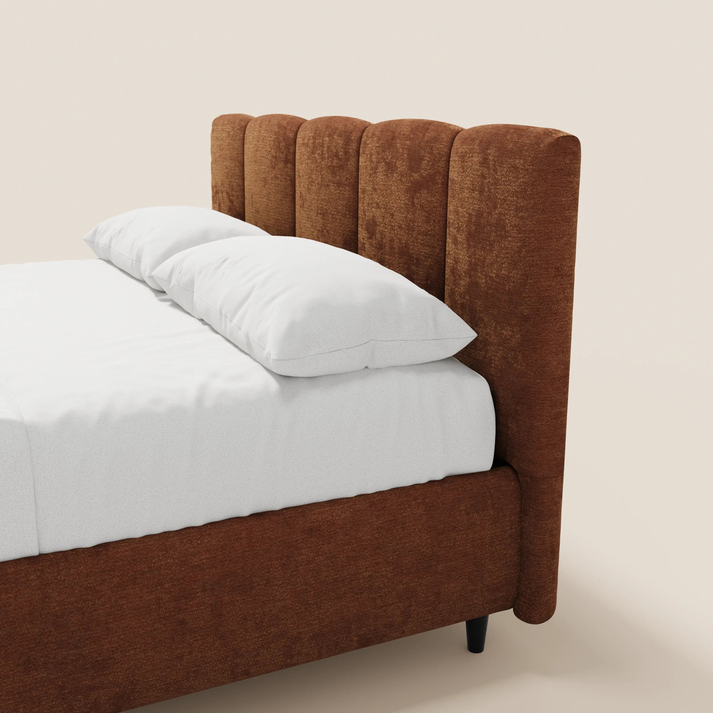 Un primo piano del letto imbottito ARKAM di Letti.store mette in risalto la testiera smerlata con cuciture verticali e le gambe corte di colore scuro. Rivestito con tessuto certificato Oeko-Tex®, questo letto in stile shabby chic presenta lenzuola bianche e due cuscini su uno sfondo bianco sporco.