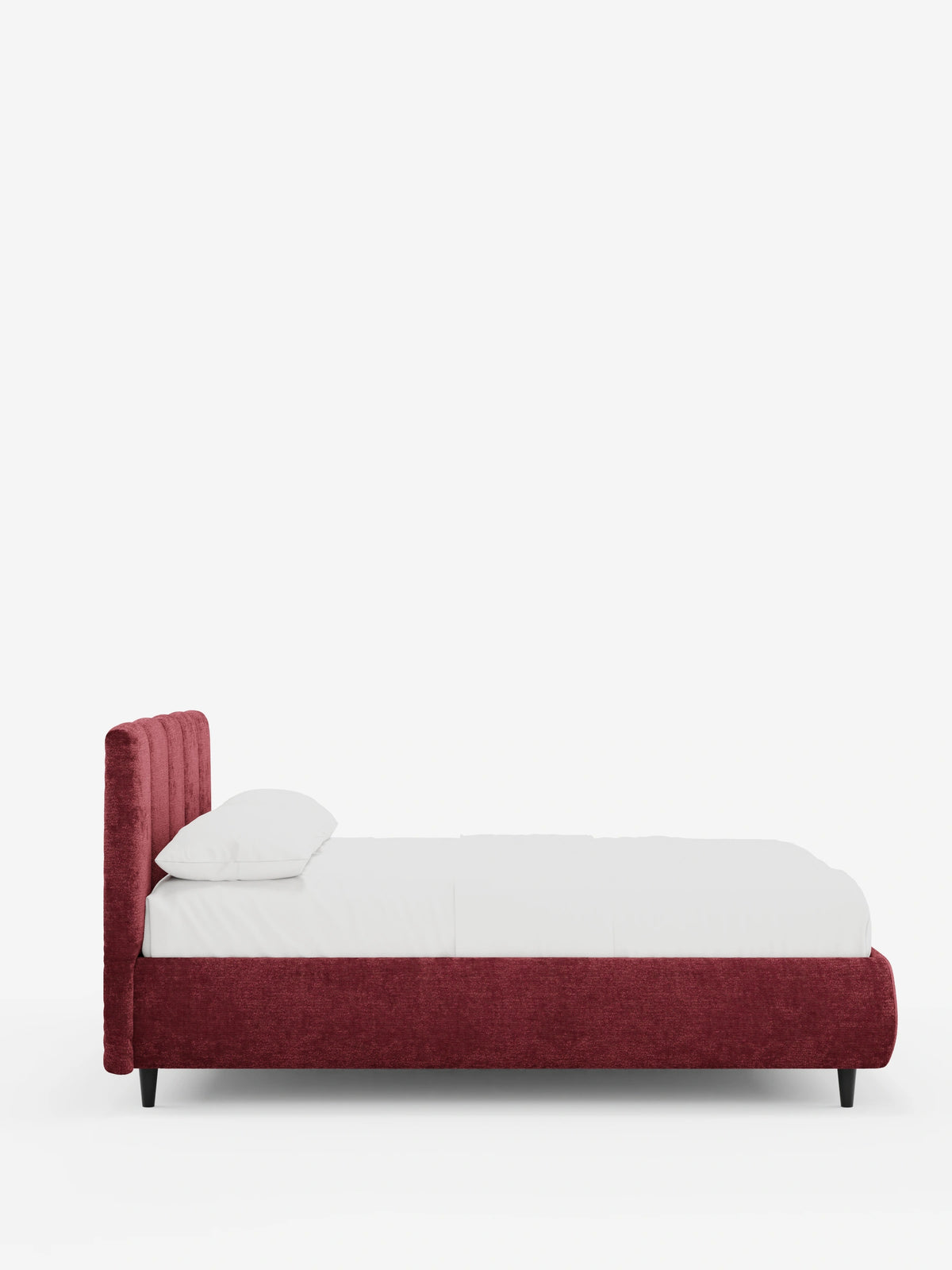 Vista laterale del letto imbottito ARKAM con contenitore e testiera a lavorazione verticale, caratterizzato da una struttura imbottita di colore rosso intenso, testiera con scanalature verticali, materasso bianco con un cuscino e gambe corte nere su uno sfondo chiaro.