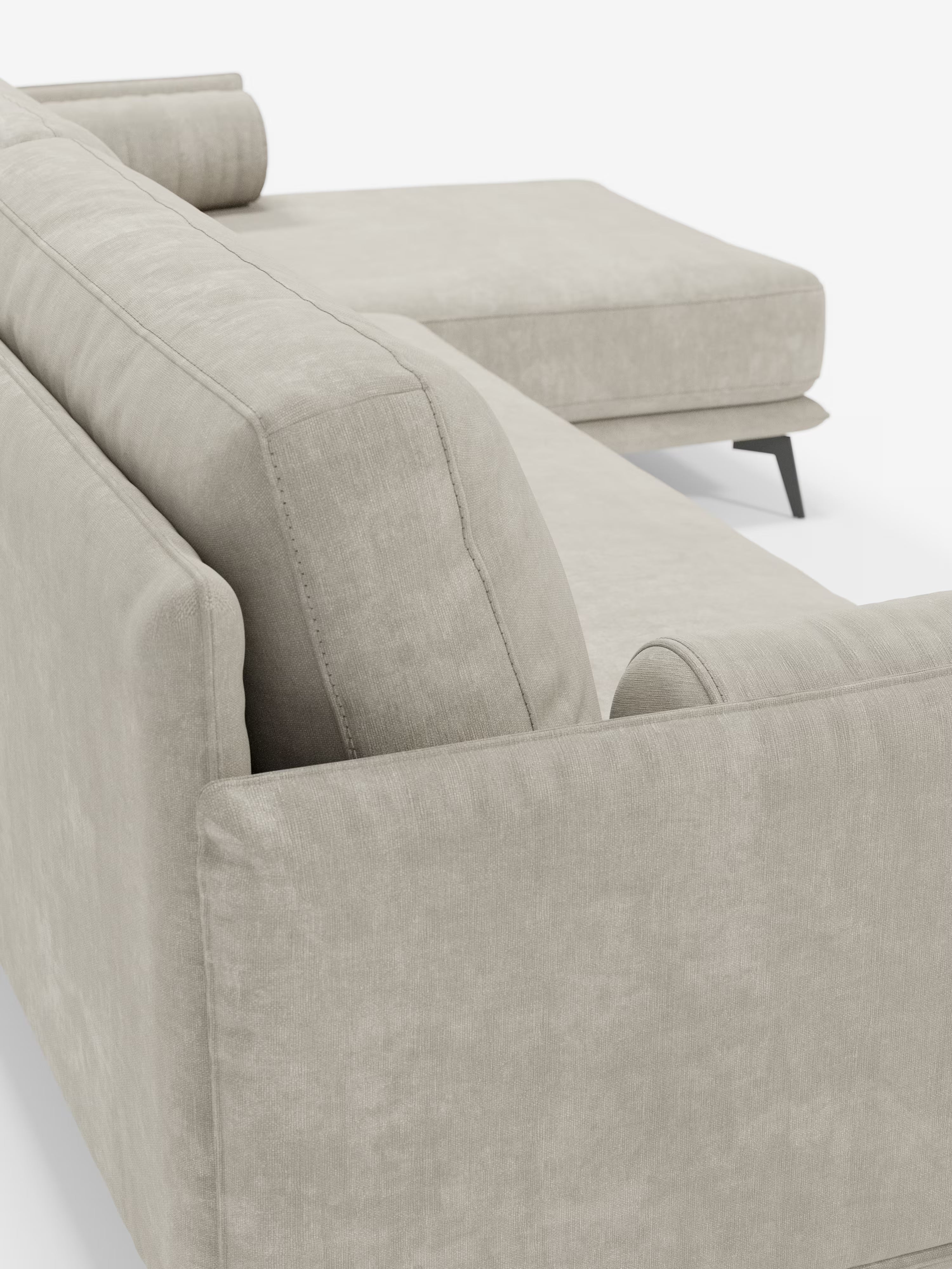 Primo piano del divano moderno angolare con penisola “Basalto” di Divani.Store, rivestito in morbido tessuto T31 testurizzato e resistente alle macchie. Questo elegante divano di produzione italiana presenta una chaise longue orientata a destra, spessi cuscini dello schienale imbottiti in piuma e due cuscini cilindrici sistemati negli angoli. La base è realizzata in metallo e le gambe sottili, angolate e di colore scuro aggiungono un tocco contemporaneo.