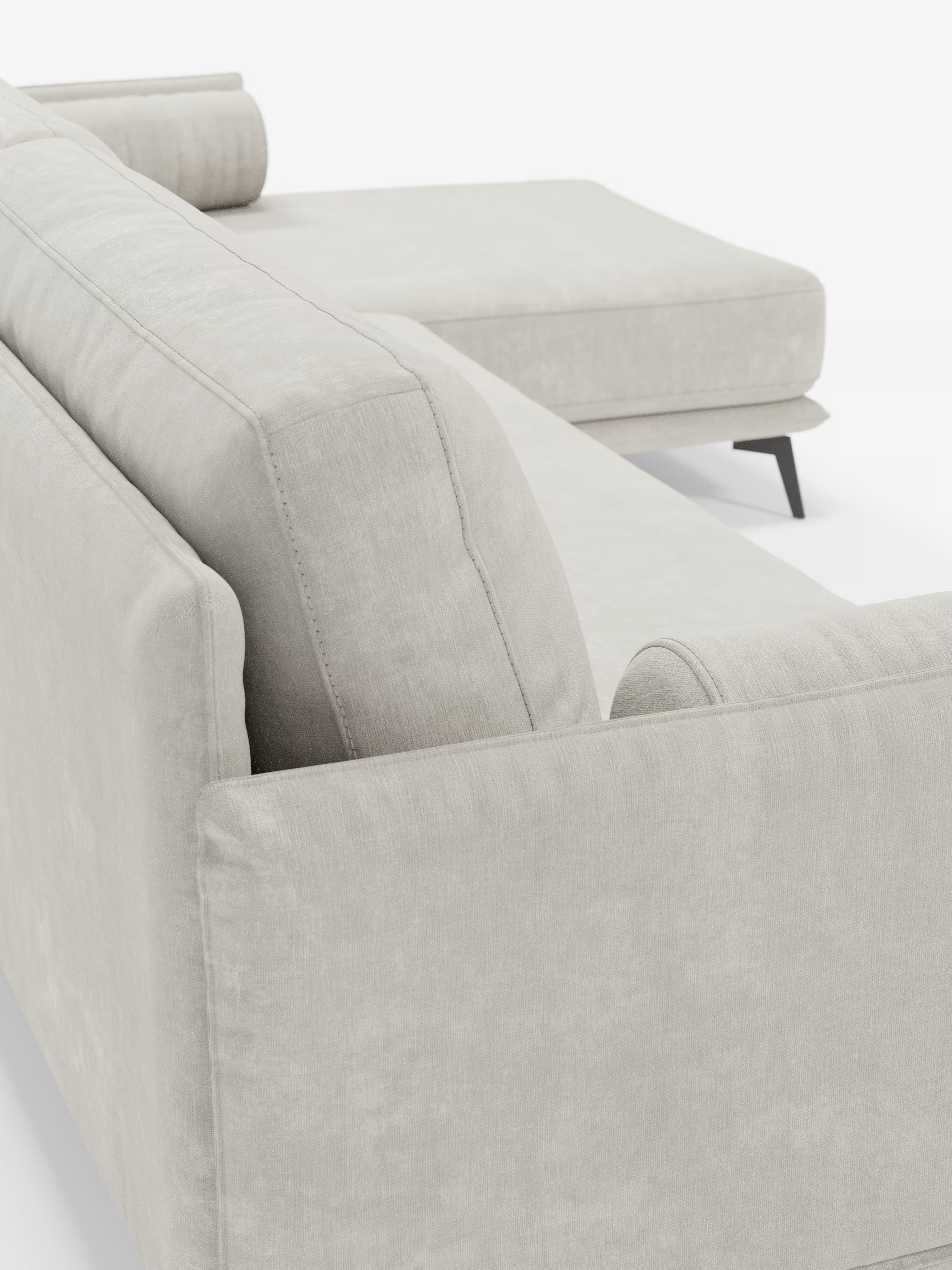 Un primo piano del “Basalto Divano moderno angolare con penisola” di Divani.Store, rivestito in tessuto T31 beige chiaro smacchiabile, mette in risalto una silhouette contemporanea dalle linee pulite, morbidi cuscini in piuma, una spaziosa sezione chaise longue che ricorda un “angolare con penisola” e sottili gambe in metallo scuro. Ritratto su uno sfondo bianco, questo elegante divano componibile mette in risalto il design moderno e il comfort eccezionale.