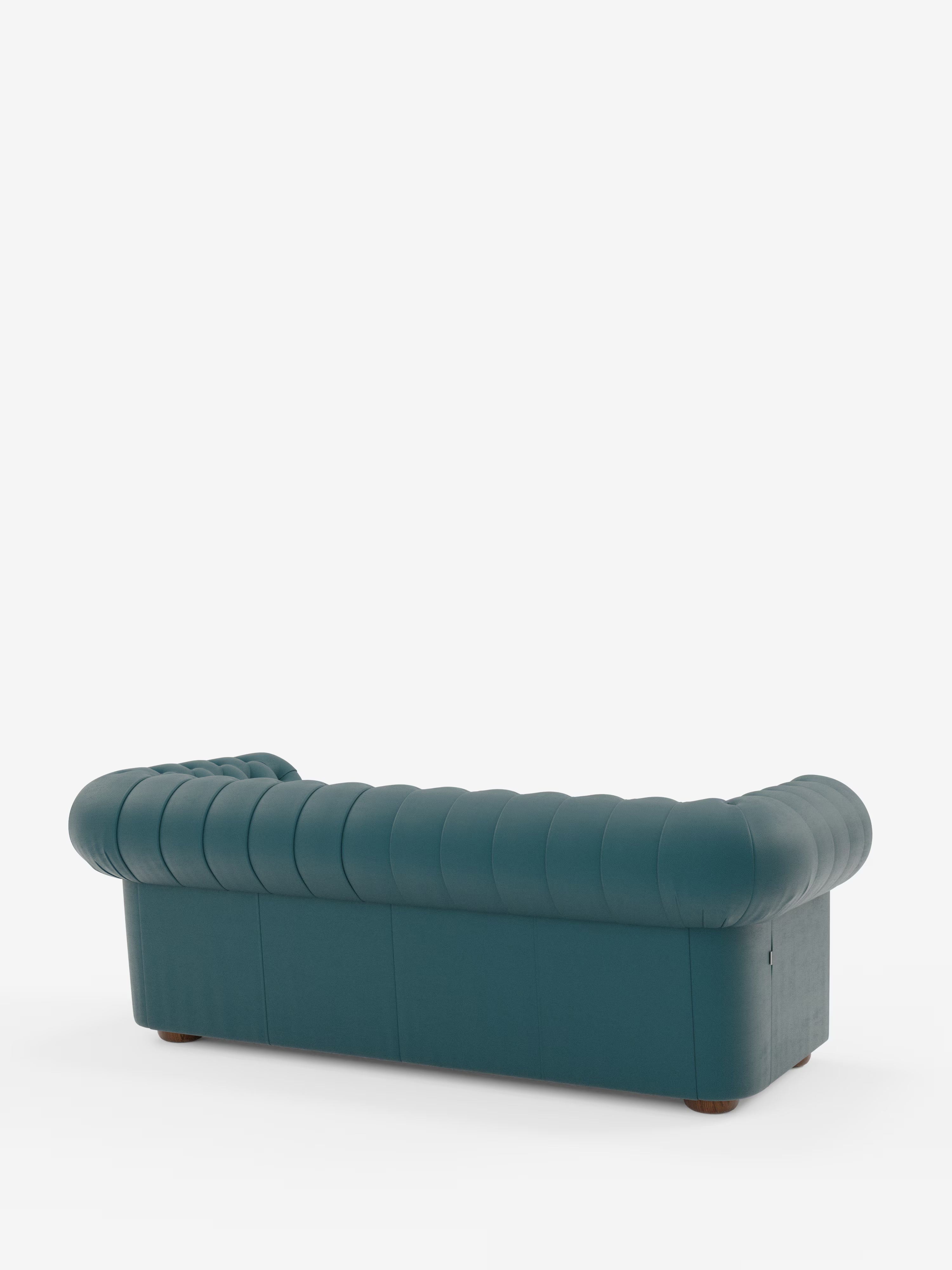 Un divano Chesterfield color verde acqua – Divano Chesterfield in vera pelle spessorata a 2 e 3 posti di Divani.Store – è ripreso di retro su uno sfondo bianco a tinta unita, caratterizzato da eleganti braccioli arrotondati, una profonda trapuntatura a bottoni e corte gambe rotonde in legno. Questo divano artigianale italiano coniuga lo stile classico con una lavorazione di alta qualità.