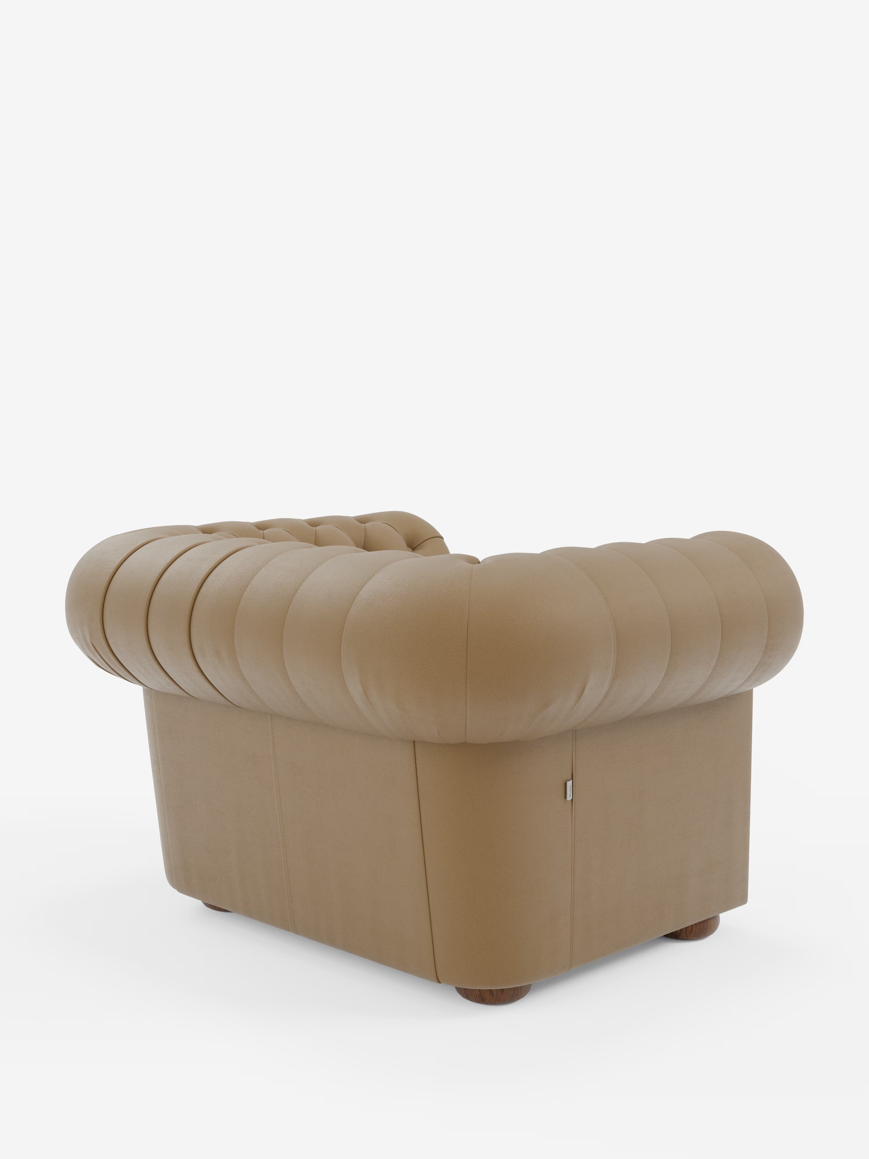 La poltrona Chester in vera pelle spessorata con capitonné artigianale di Divani.Store è una poltrona in pelle color cuoio con braccioli e schienale dalle linee armoniosamente arrotondate, caratterizzata da una profonda trapuntatura a bottoni e da un rivestimento sontuoso. Sostenuta da piedini corti e arrotondati in legno, questa poltrona è ripresa in una prospettiva posteriore su uno sfondo bianco a tinta unita, rendendola una scelta ideale per ambienti d’arredo di lusso.