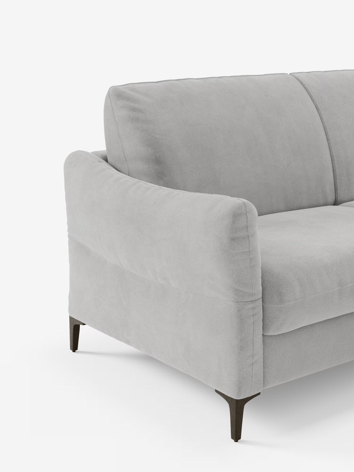 Un primo piano del divano letto Dalia a 2, 3 e 4 posti con materasso H18 di Divani.Store, rivestito in tessuto vellutino T30 grigio chiaro, moderno e resistente alle macchie, caratterizzato da braccioli curvi, morbidi cuscini e sottili gambe in metallo nero. L'immagine mostra solo il lato sinistro e parte dello schienale su uno sfondo bianco.