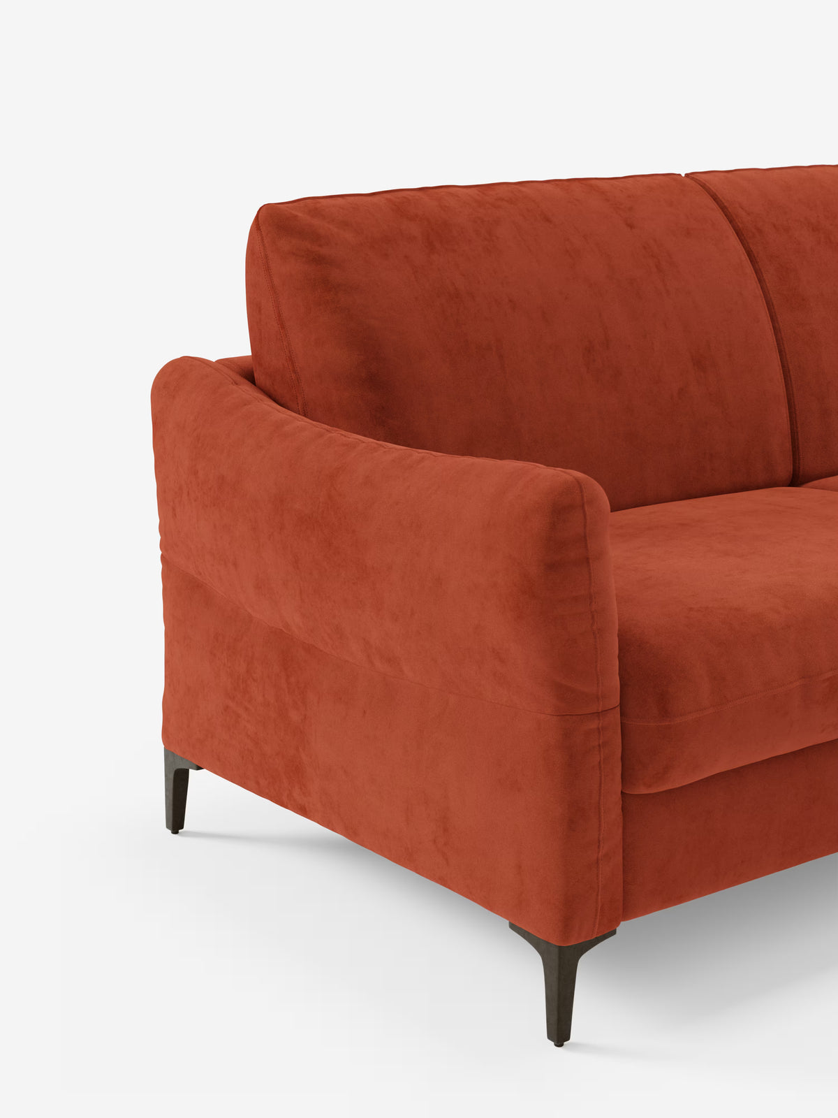 Una veduta parziale del divano letto Dalia color arancio bruciato di Divani.Store, caratterizzato da morbidi cuscini, rivestimento in vellutino T30 liscio e resistente alle macchie, braccioli arrotondati e sottili gambe in metallo nero, su uno sfondo bianco a tinta unita.