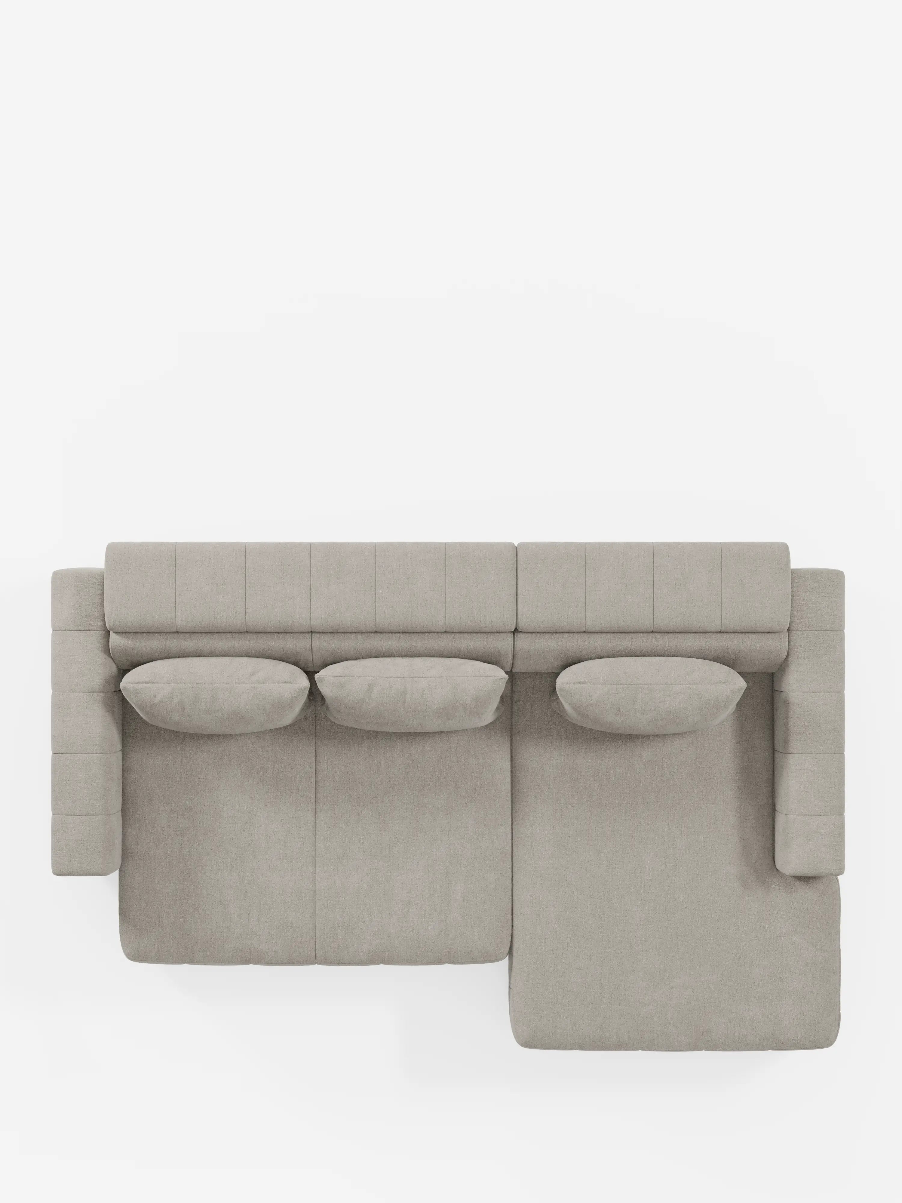 Vista dall’alto del divano angolare Doric con penisola e sedute allungabili con relax elettrico di Divani.Store, rivestito in tessuto T23 facile da pulire in una tonalità di grigio chiaro. Questo moderno divano componibile è dotato di tre cuscini rettangolari, poggiatesta regolabili e una chaise longue estensibile sul lato destro. Le sue linee pulite e il design minimalista lo rendono la scelta ideale per gli spazi abitativi contemporanei.